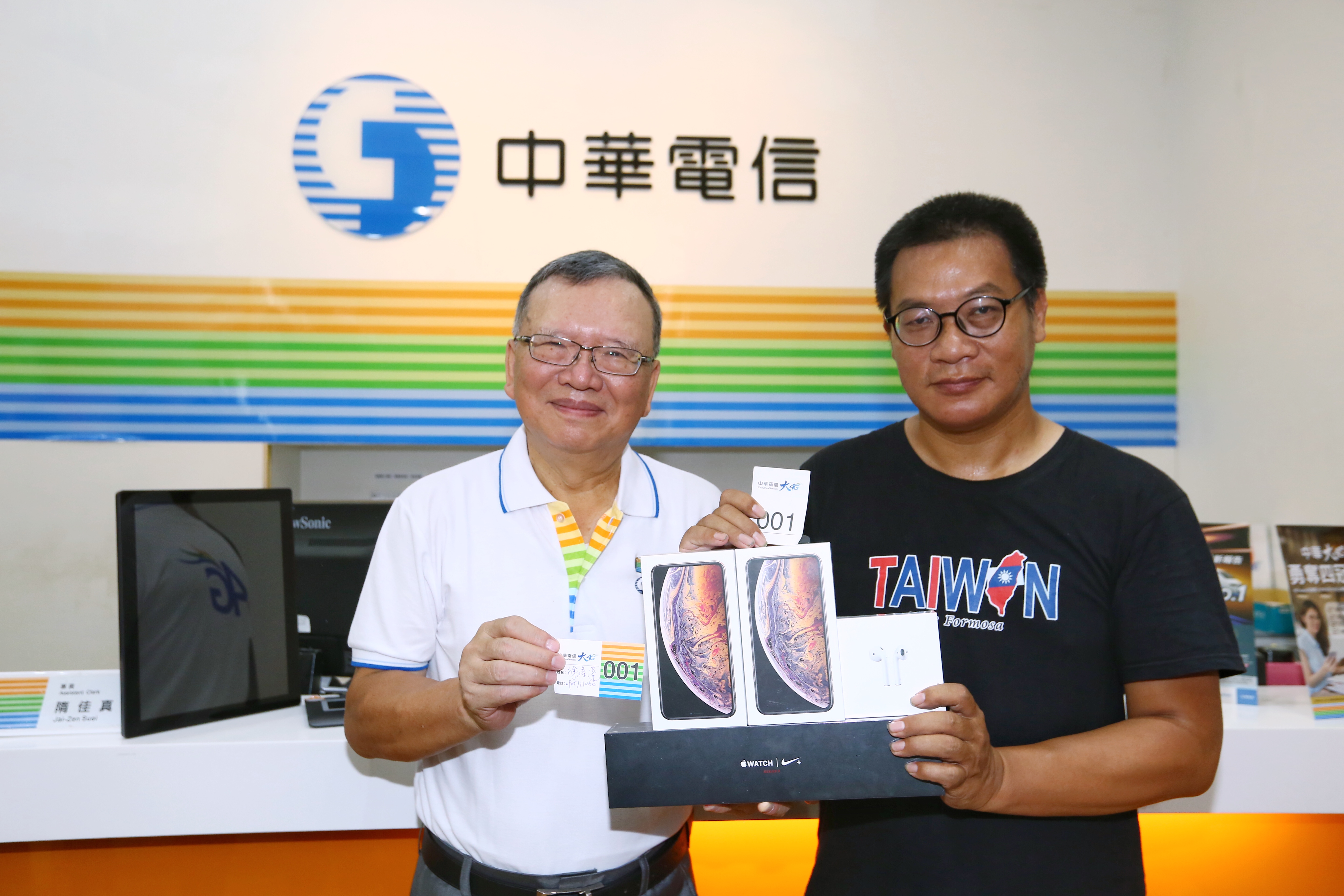 在中華電信排了91小時的搶頭香果粉Mike，董事長鄭優（左）贈送1支最頂規iPhone XS Max 512GB。