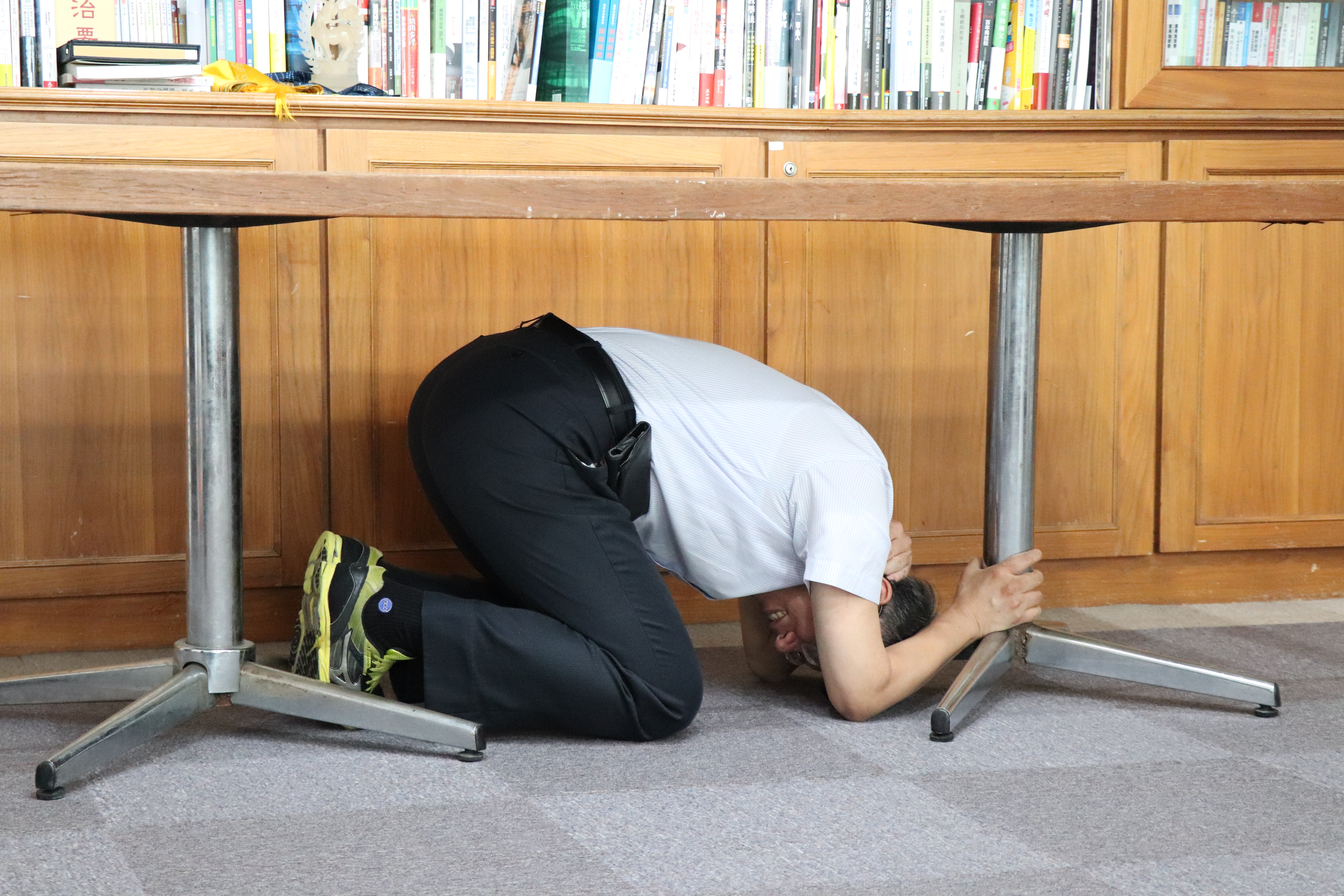 官員們在「台灣抗災資訊網」演練避難動作，圖中完全看不到臉部的是台北市長柯文哲，他的動作也最標準。（翻攝自台灣抗災資訊網）