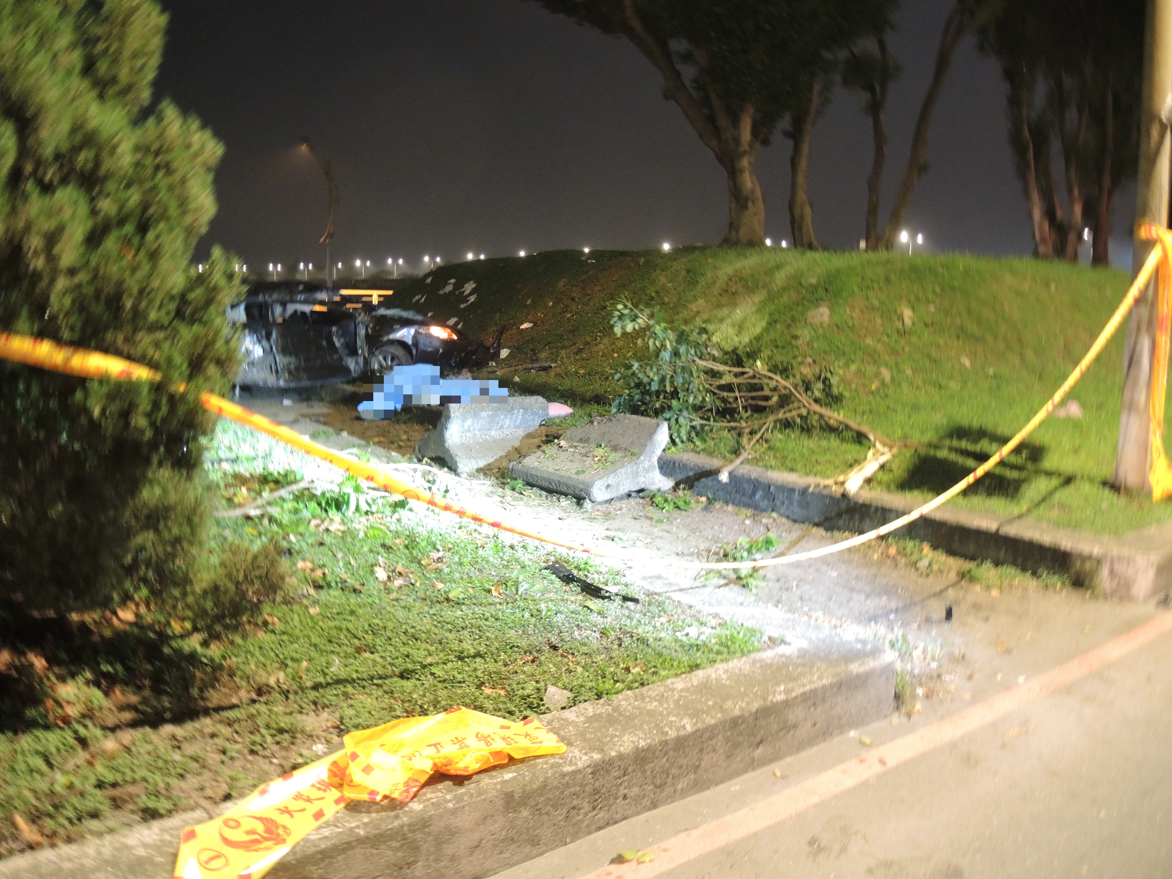 蔡男駕車疑似車速過快失控,先擦撞到路旁右側水泥護攔,再衝到對向河堤並發生翻覆,車輛嚴重變形。(翻攝畫面)