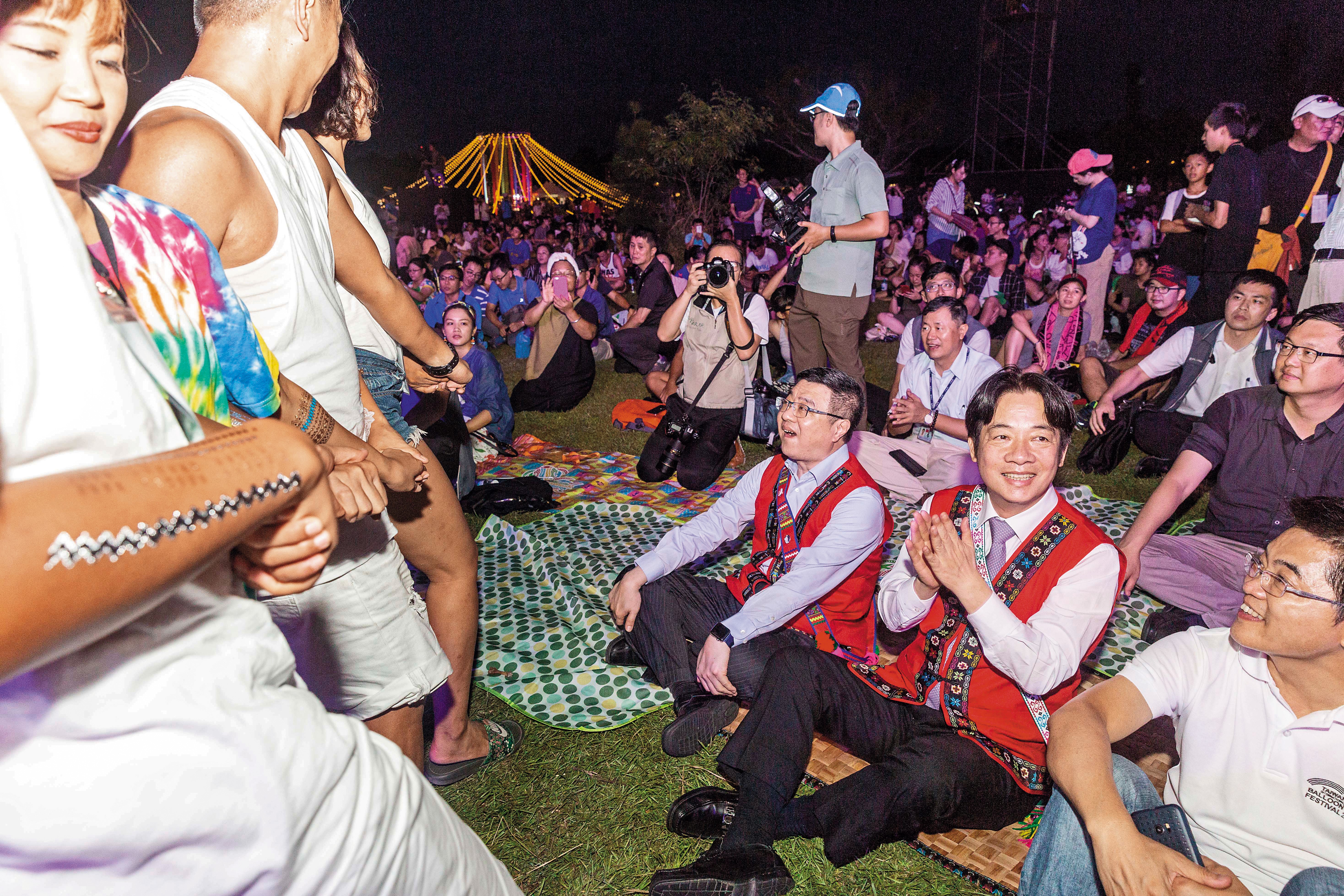 行政院長賴清德(中)到場體驗草地音樂節活動,民眾跳起原住民舞蹈表示歡迎。右為台東縣長黃健庭,左為行政院祕書長卓榮泰。