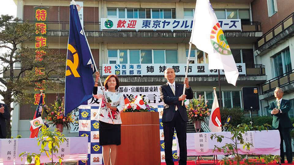 林姿妙常對外宣稱鎮長任內沒出國，但本刊在公務出國報告資訊網找到她2016年訪日資料（圖右），她還與日本西都市長開記者會（圖左）。（翻攝羅東鎮公所臉書）