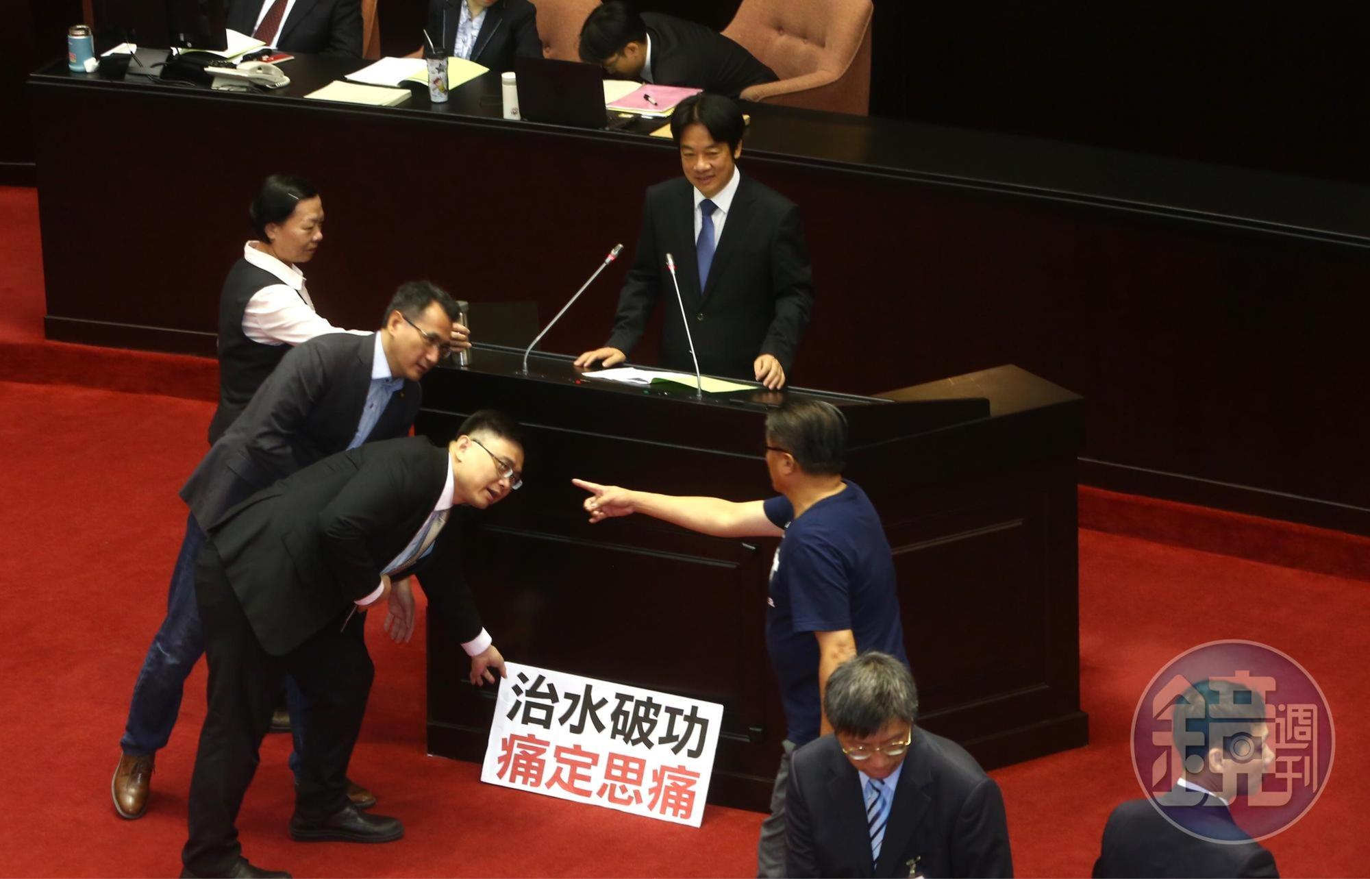 賴清德上台報告時,議場人員把國民黨團的抗議標語清除。