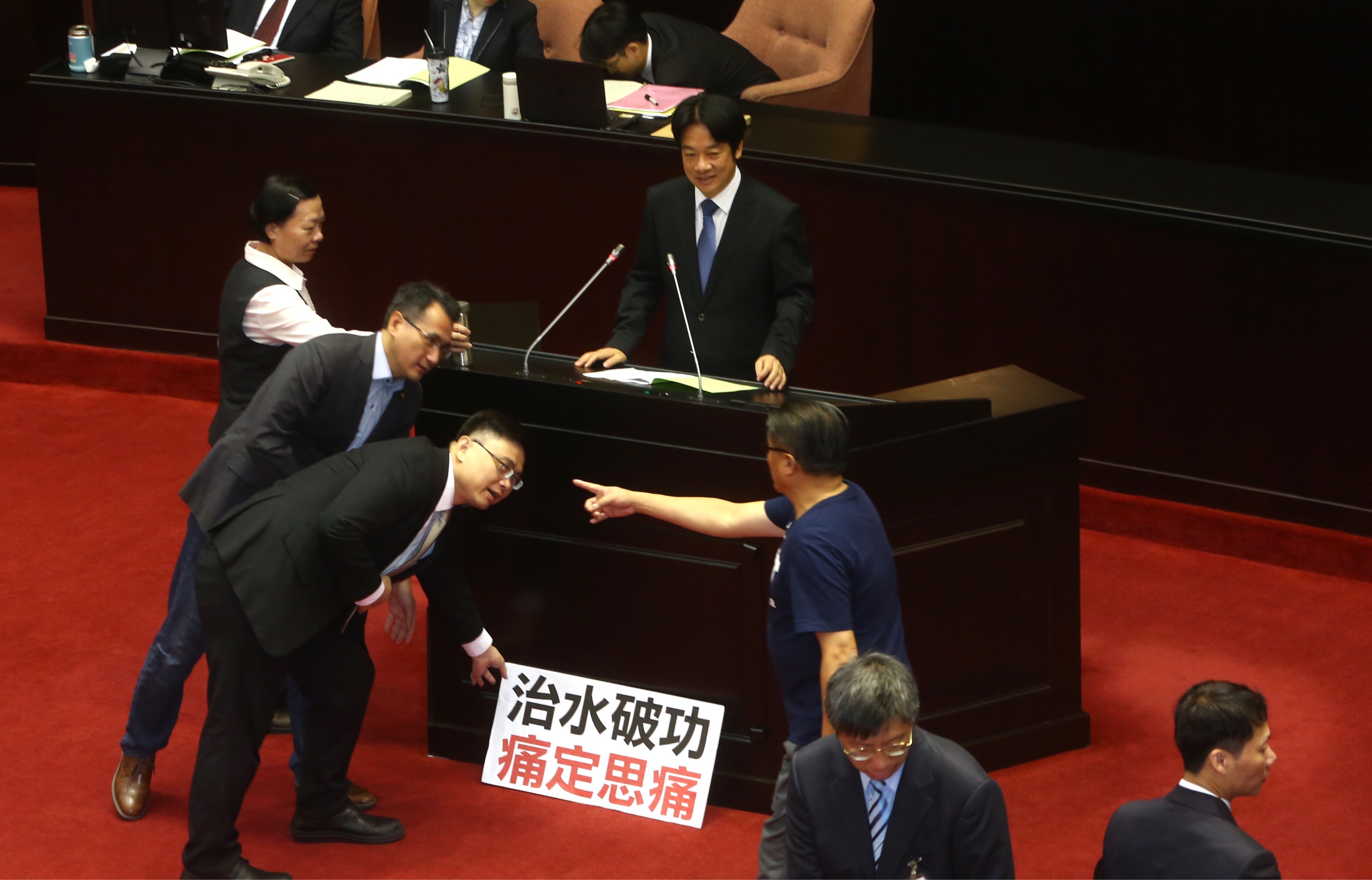 賴清德上台報告時，議場人員把國民黨團的抗議標語清除。