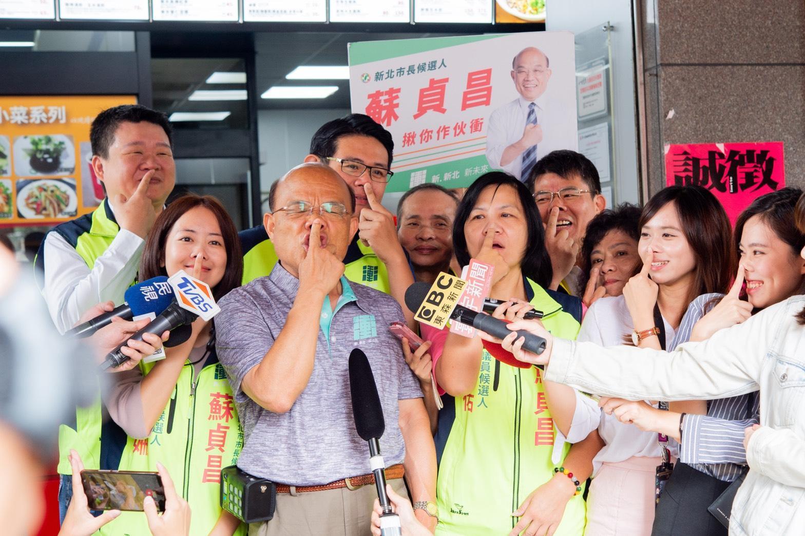 民進黨新北市長參選人蘇貞昌今接受媒體採訪時做出模仿豬叫的動作,表情相當逗趣。(蘇貞昌競選辦公室提供)