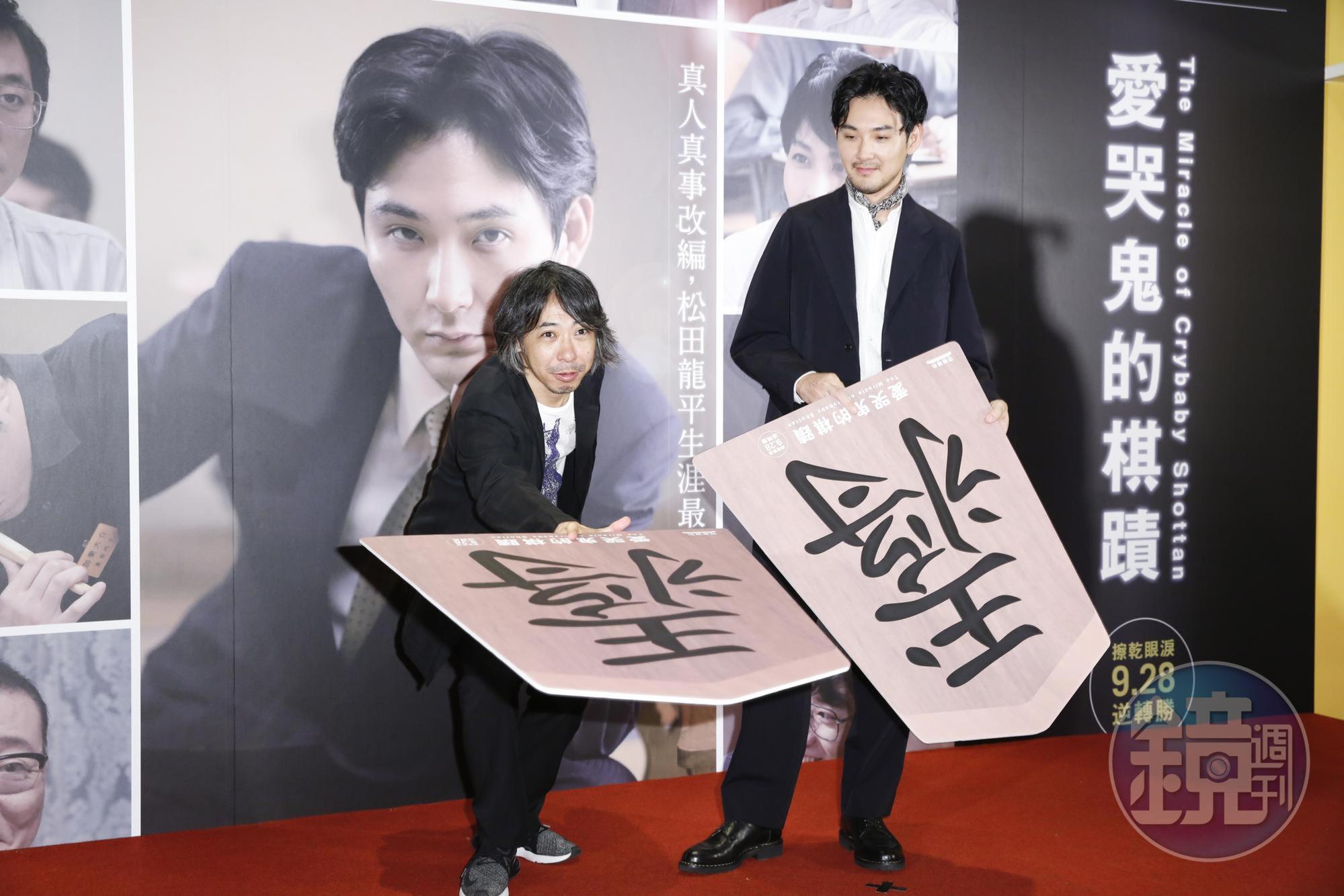 松田龍平(右)和導演豐田利晃拿著大型將棋調皮地擺出下棋姿勢。