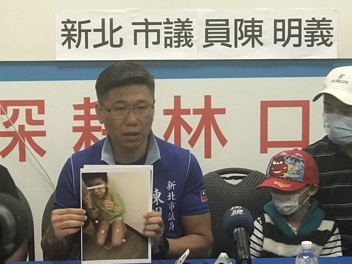 吳父帶著兒子在新北市議員陳明義陪同下召開記者會,控訴第二任妻子對兒子施虐。(翻攝畫面)