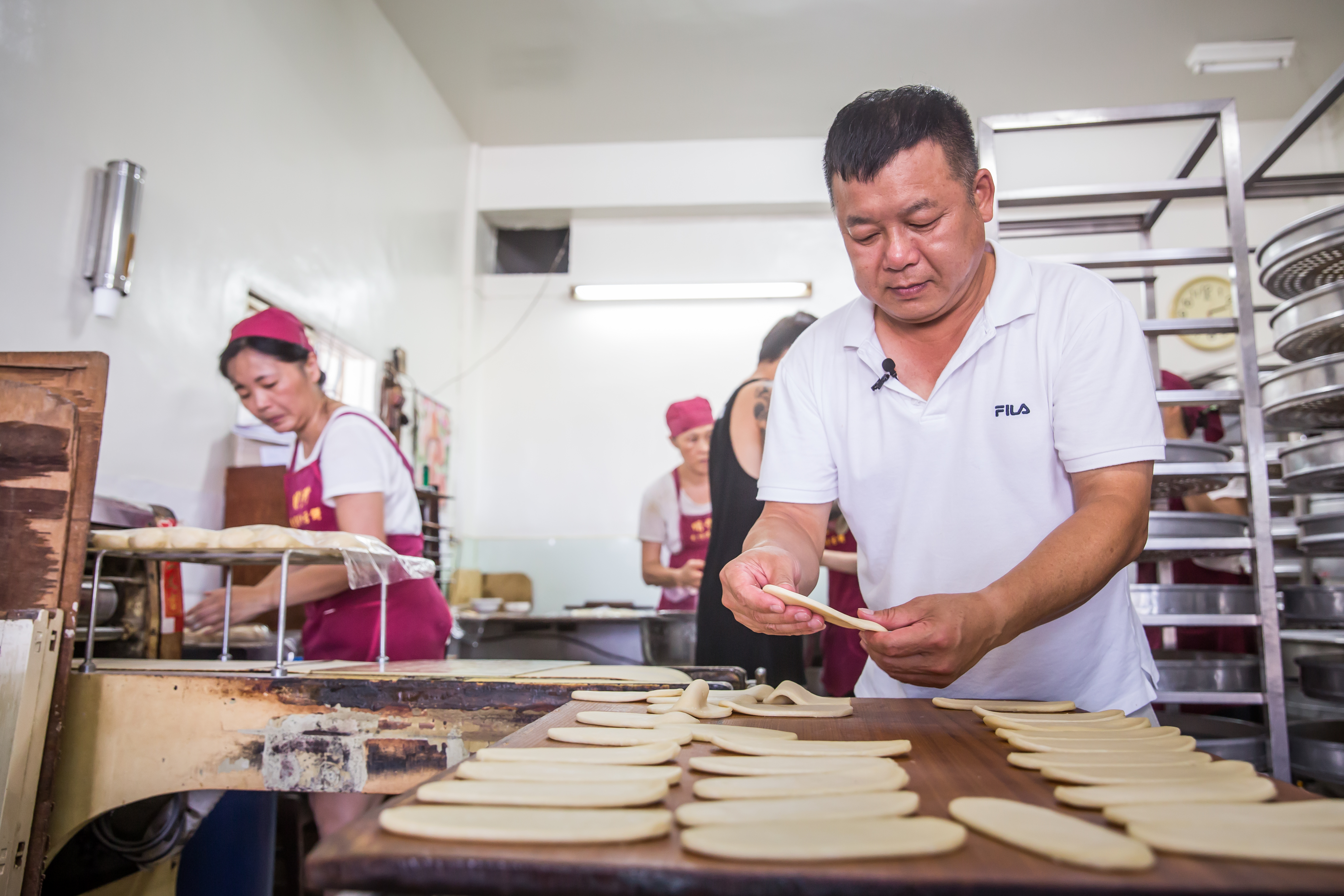 蘇正興（中）29年前臨危接下明豐珍兔仔寮牛舌餅家業，至今仍保留純手工製作流程。