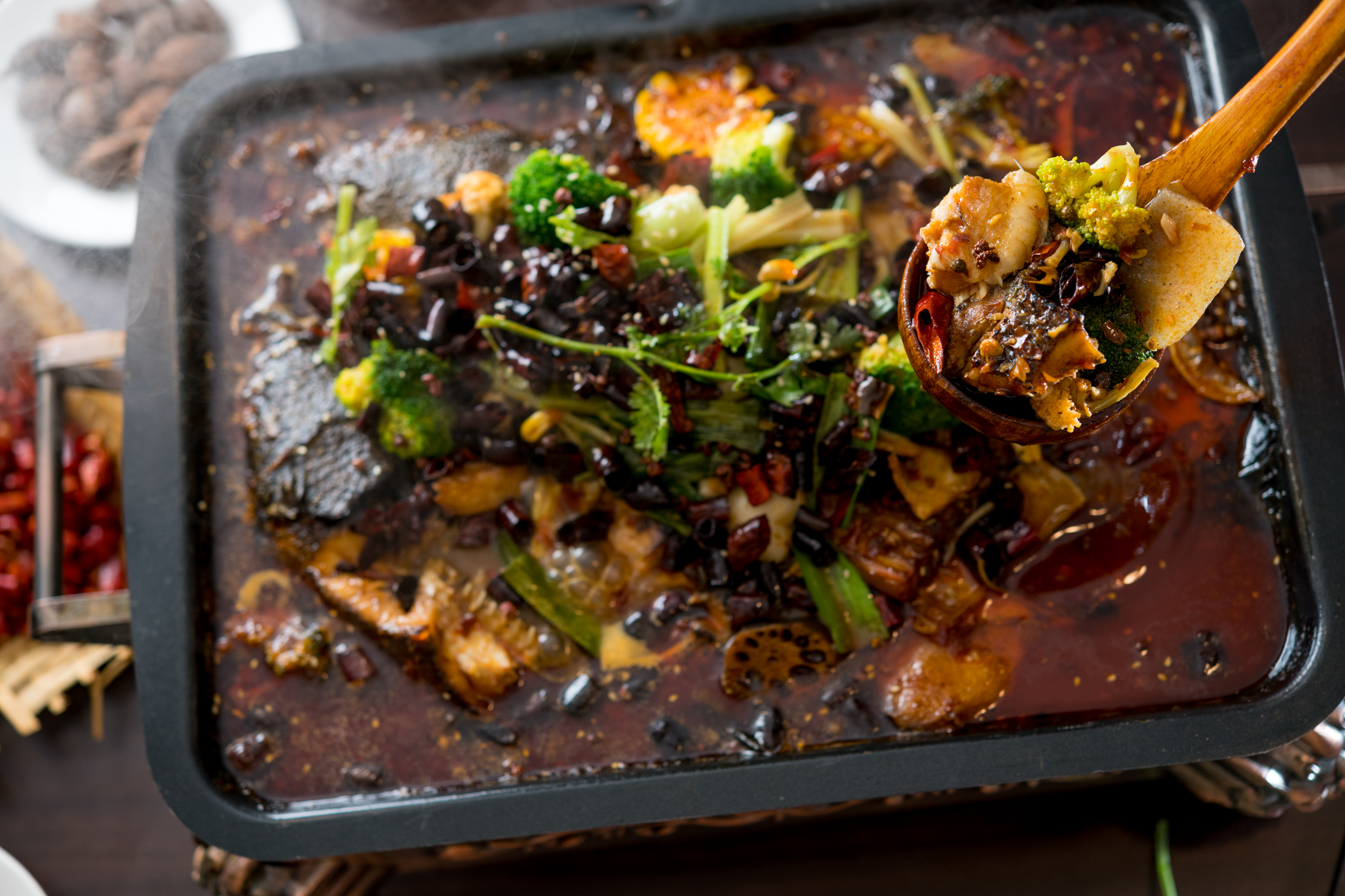 「諸葛烤魚」是用肉質肥厚的鱧魚，以特製麻辣醬燒煮入味，魚肉吸附豐富香料的香、麻、辣。（1,288元／份，需預訂）