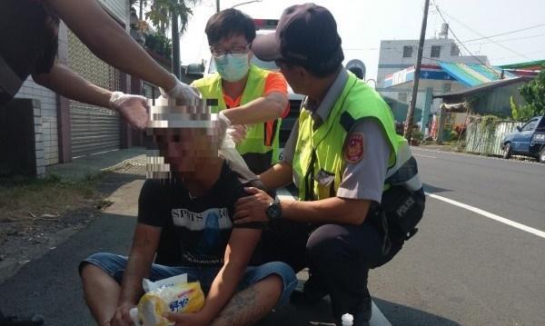 廖姓男子血淋淋持刀街頭暴走嚇壞路人,警方與消防人員緊急處理。(警方提供)