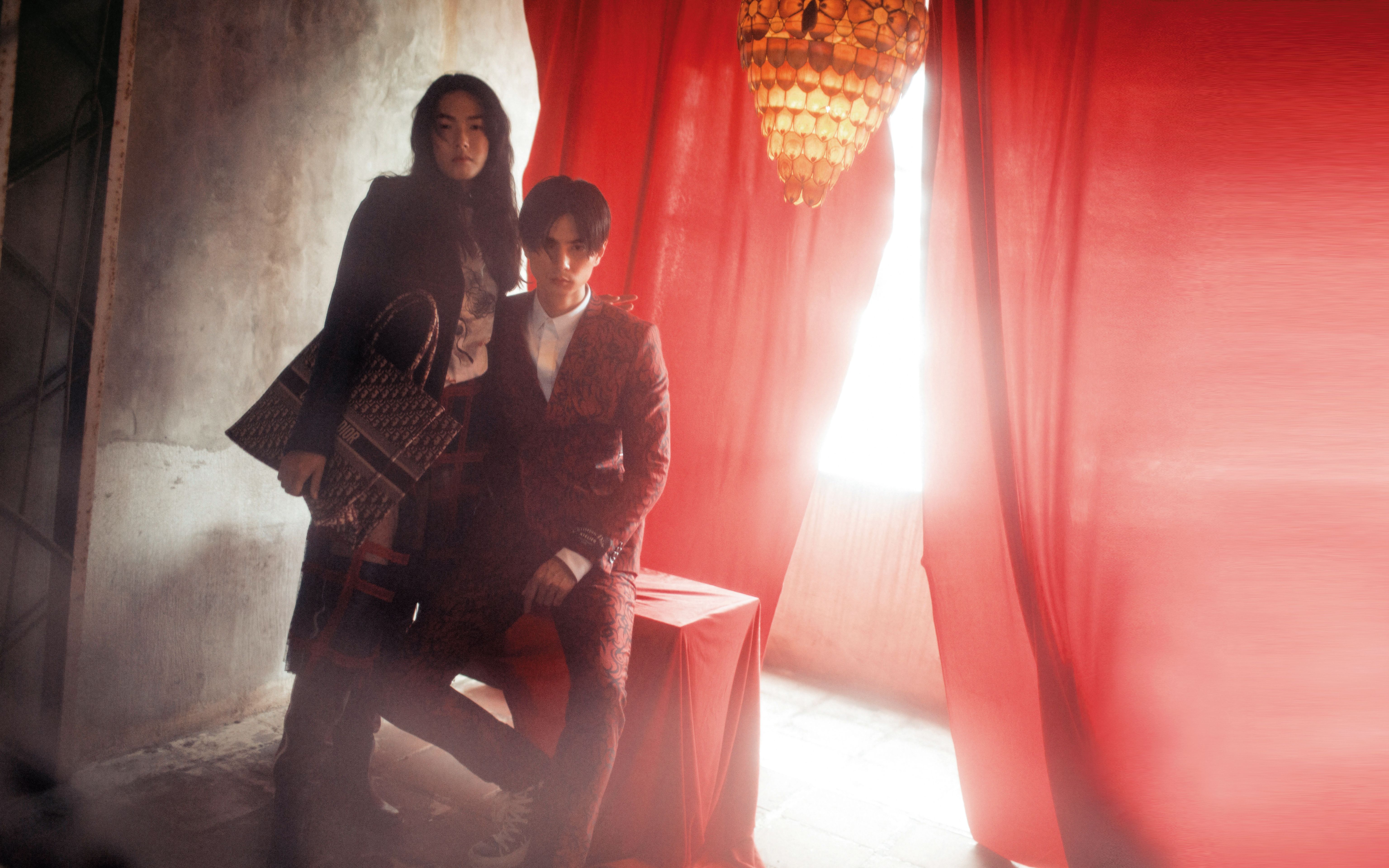 女，海軍藍格紋夾克，NT$140,000；白色棉質T-shirt，NT$25,000；紅色蕾絲格紋紗裙，NT$290,000；Dior Book Oblique酒紅色帆布托特包，NT$86,000；Diorider黑色霧面小牛皮高筒靴，NT$82,000。男，部落圖騰西裝上衣，NT$79,000；白色小蜜蜂襯衫，NT$19,500；部落圖騰西裝褲，NT$32,000；黑色帆布部落圖騰印花高筒休閒鞋，NT$31,000。All by Dior