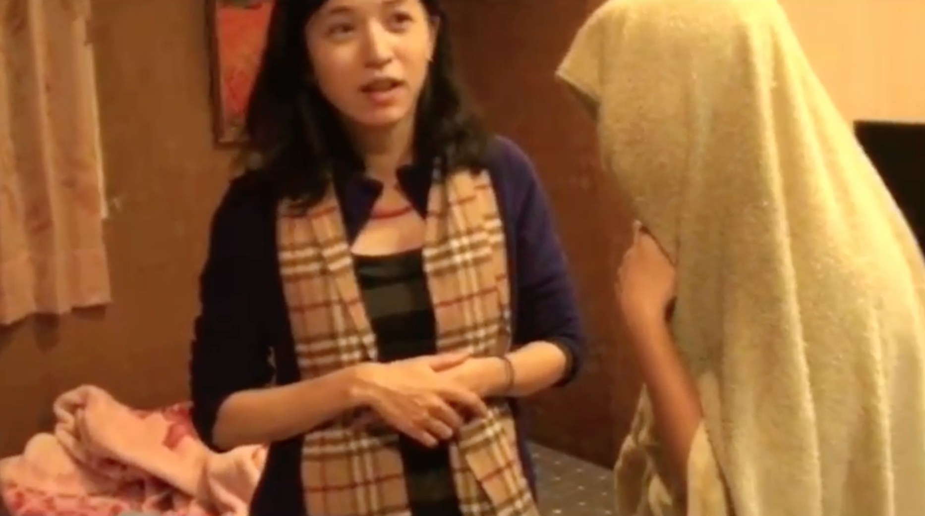 不願面對鏡頭的泰籍女子以布巾遮頭。(警方提供)