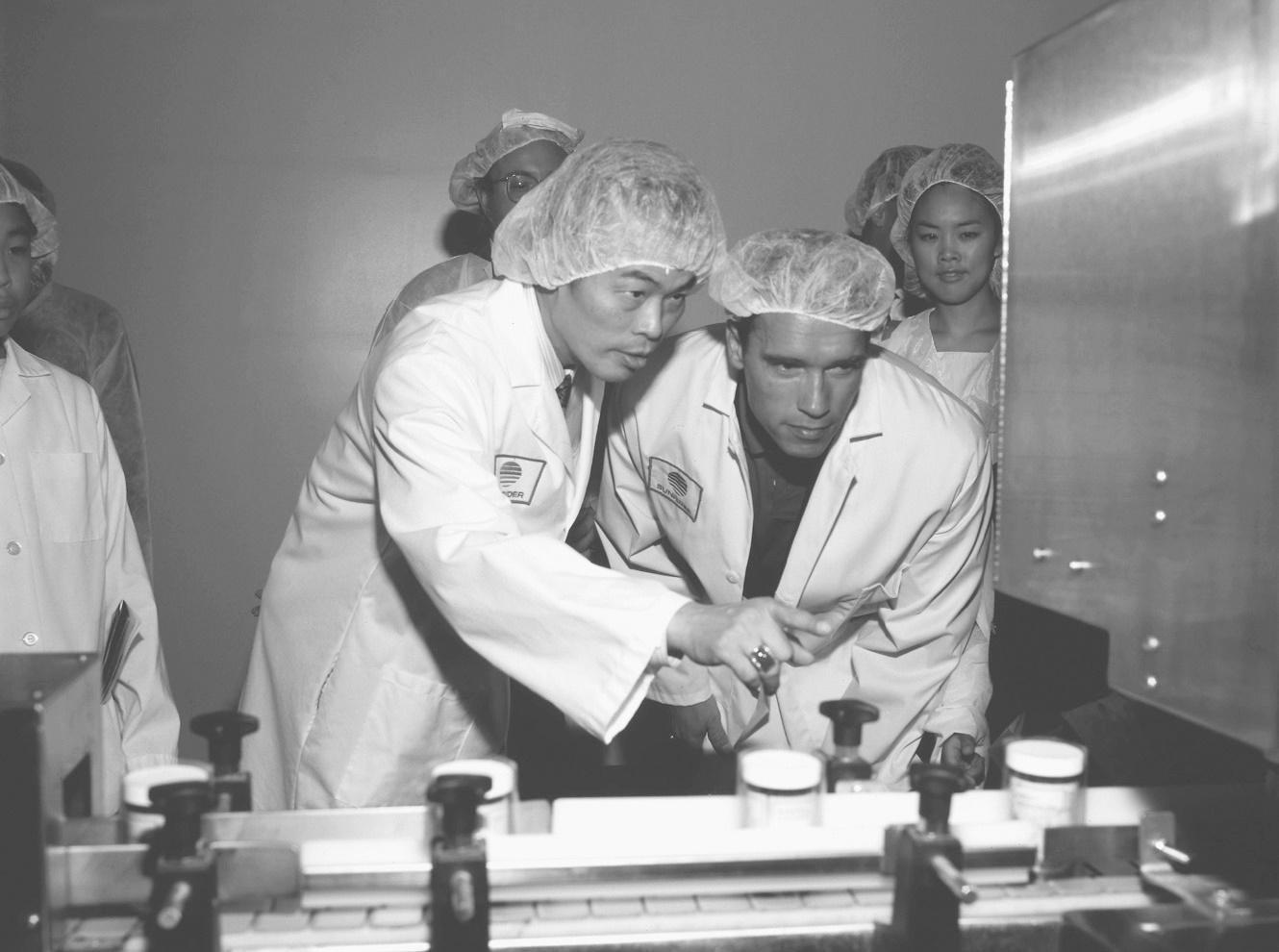 陳得福(左)親自向前加州州長阿諾‧史瓦辛格(右)解說中草藥濃縮與萃取的奧祕。(仙妮蕾德提供)