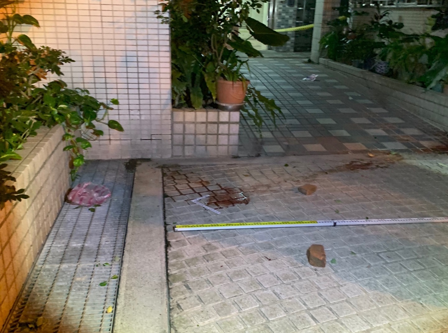 梁母頭顱被砍下並丟到國宅門口，嚇壞過路民眾。（翻攝畫面）