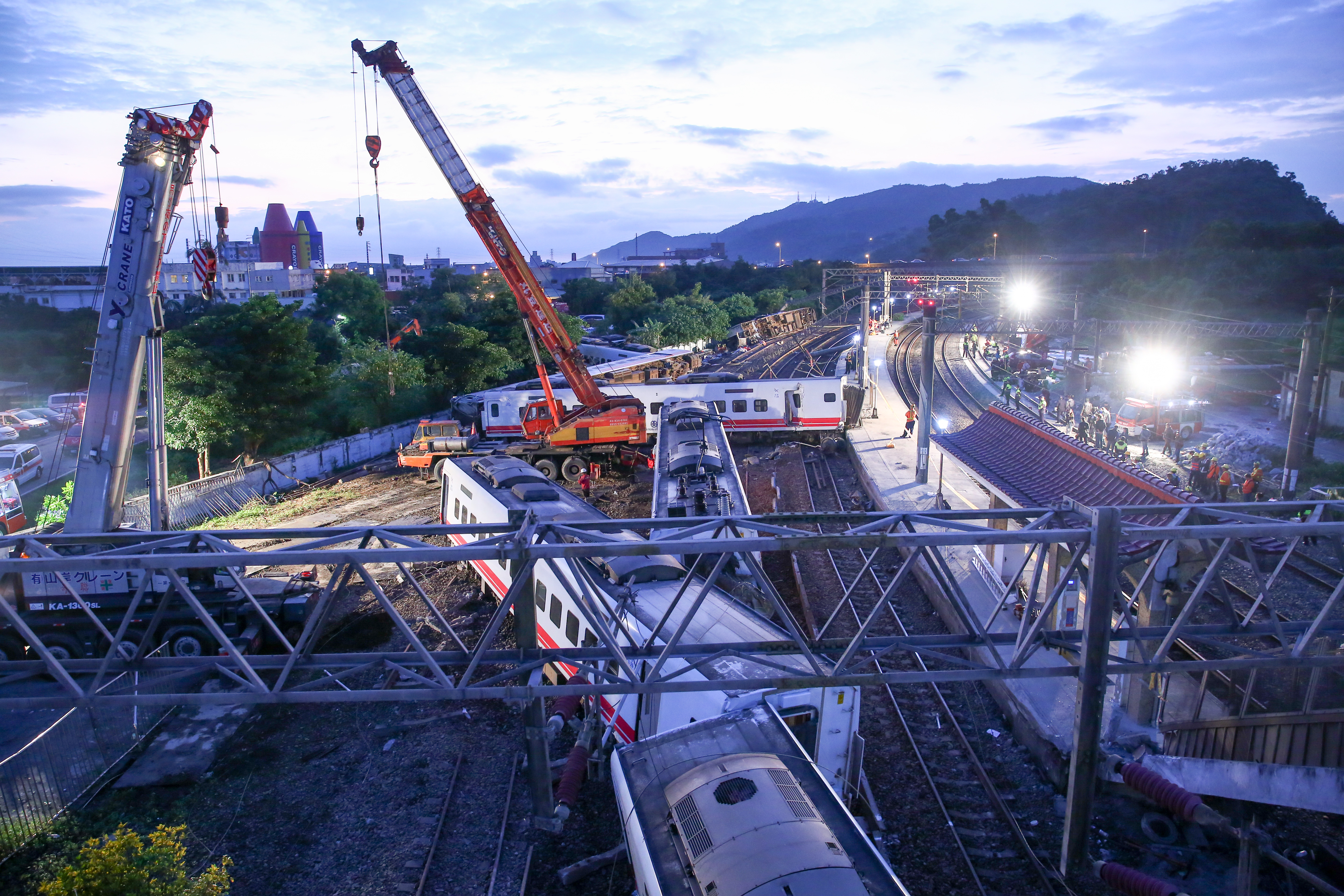 大型吊車漏夜吊掛翻覆的列車,趕在上午前完成單線通車。