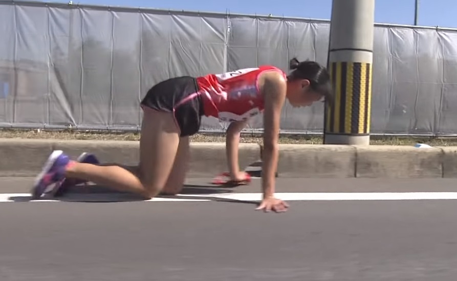 日本一場馬拉松接力賽，選手飯田怜途中腿骨骨折，仍堅持以跪爬姿勢完成比賽。（圖翻攝自ZEROパラドンYoutube頻道）