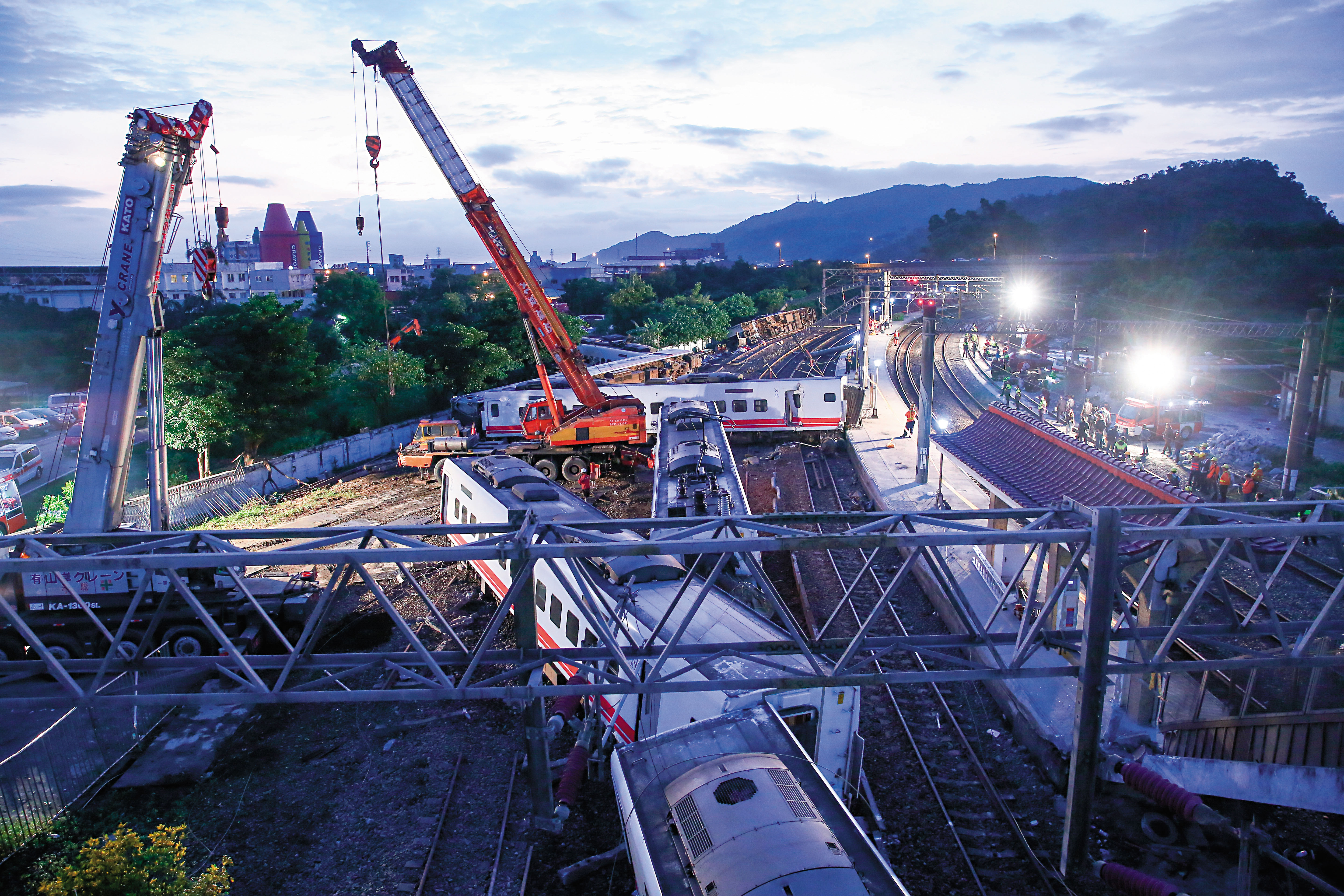 大型吊車漏夜吊掛翻覆的列車，趕在22日上午前完成單線通車。
