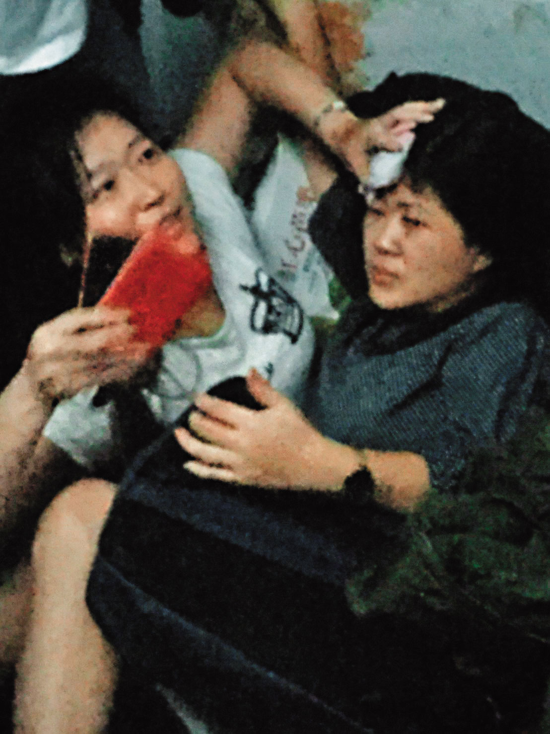 列車出軌後，輕傷的戴太太在車廂內以手按壓受傷者頭部，等待救援。（戴先生提供）