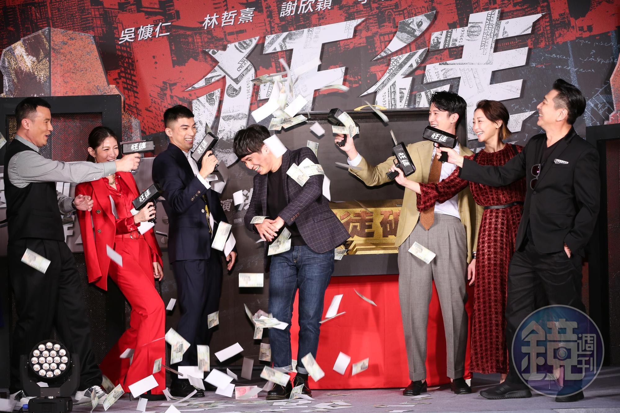 李洺中（左1）、李千娜（左2）、林哲熹（左3）、吳慷仁（右3）、謝欣穎（右2）、高捷（右1），一起拿噴鈔機，對著導演洪子烜（中）噴灑道具鈔票。 