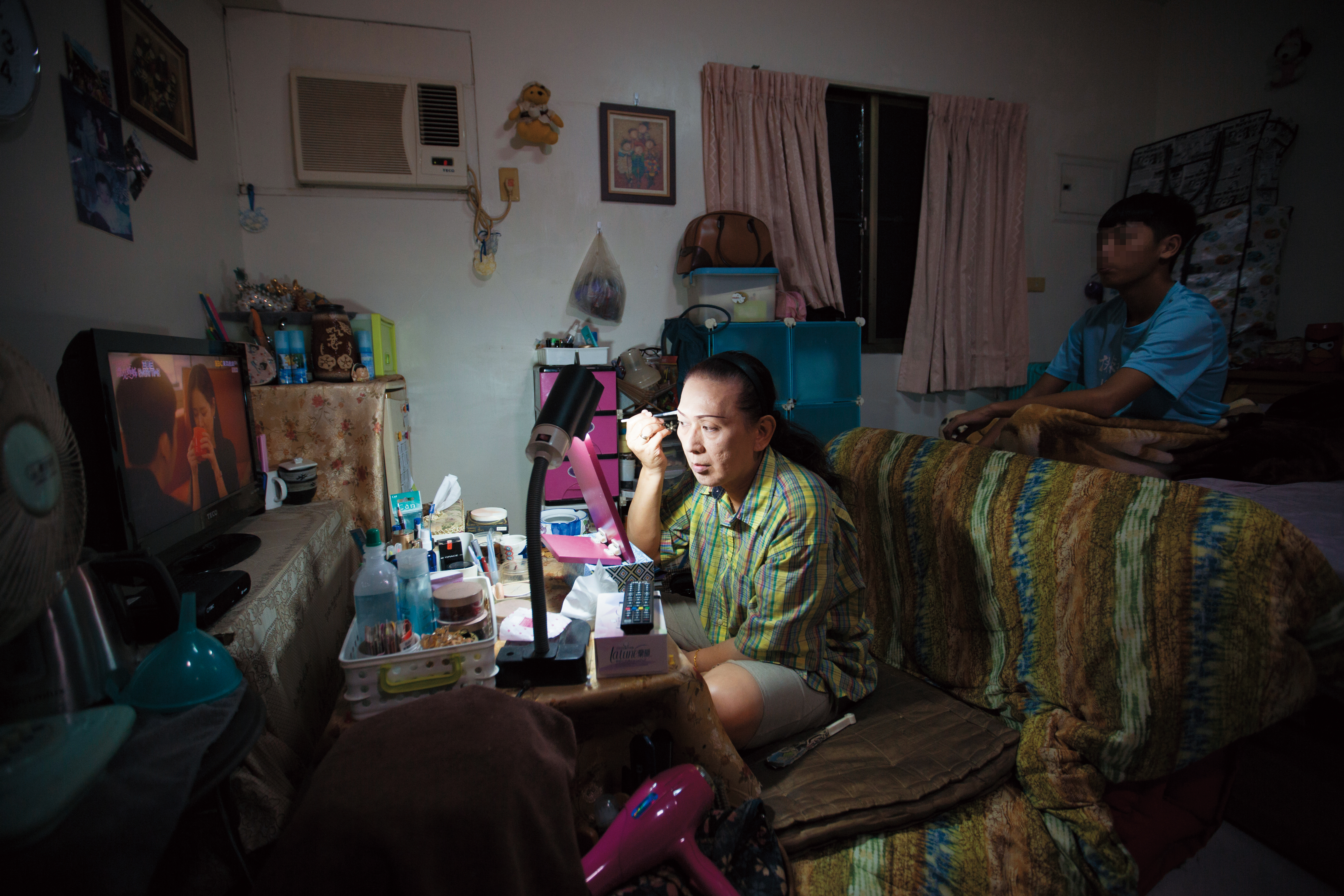 鍾玲（左）正在化妝。她說自己化妝一定要開電視，透露了寂寞的日子，需要一點聲音陪伴。