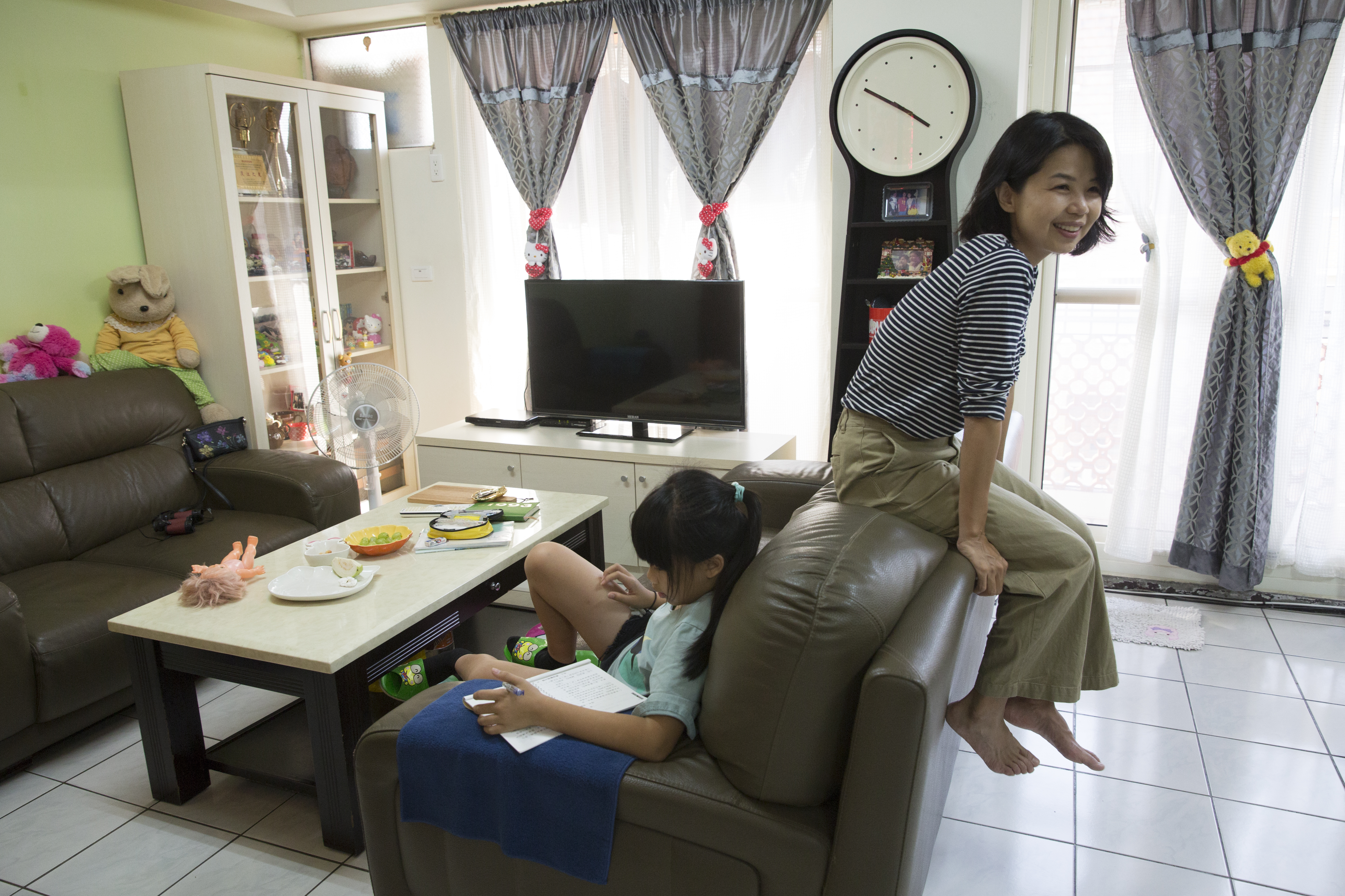 回到媽媽家，陳慧翎（右）顯得很自在，跳上沙發踢起腳來，模樣很可愛。她與妹妹的女兒（左）感情也好，曾一起到日本旅行。