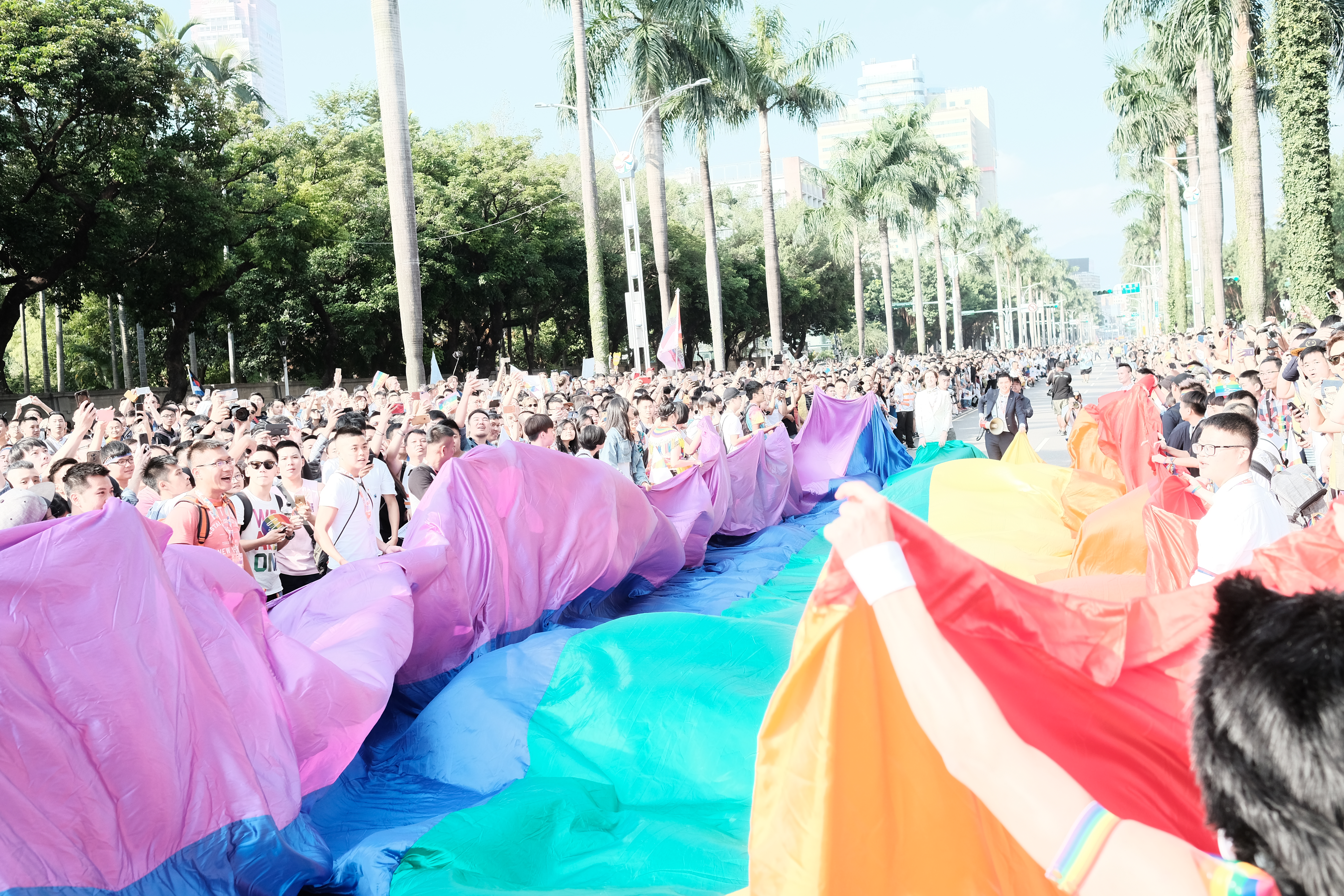 民眾鋪上彩虹旗，引起群眾圍觀、爭相拍照留念。