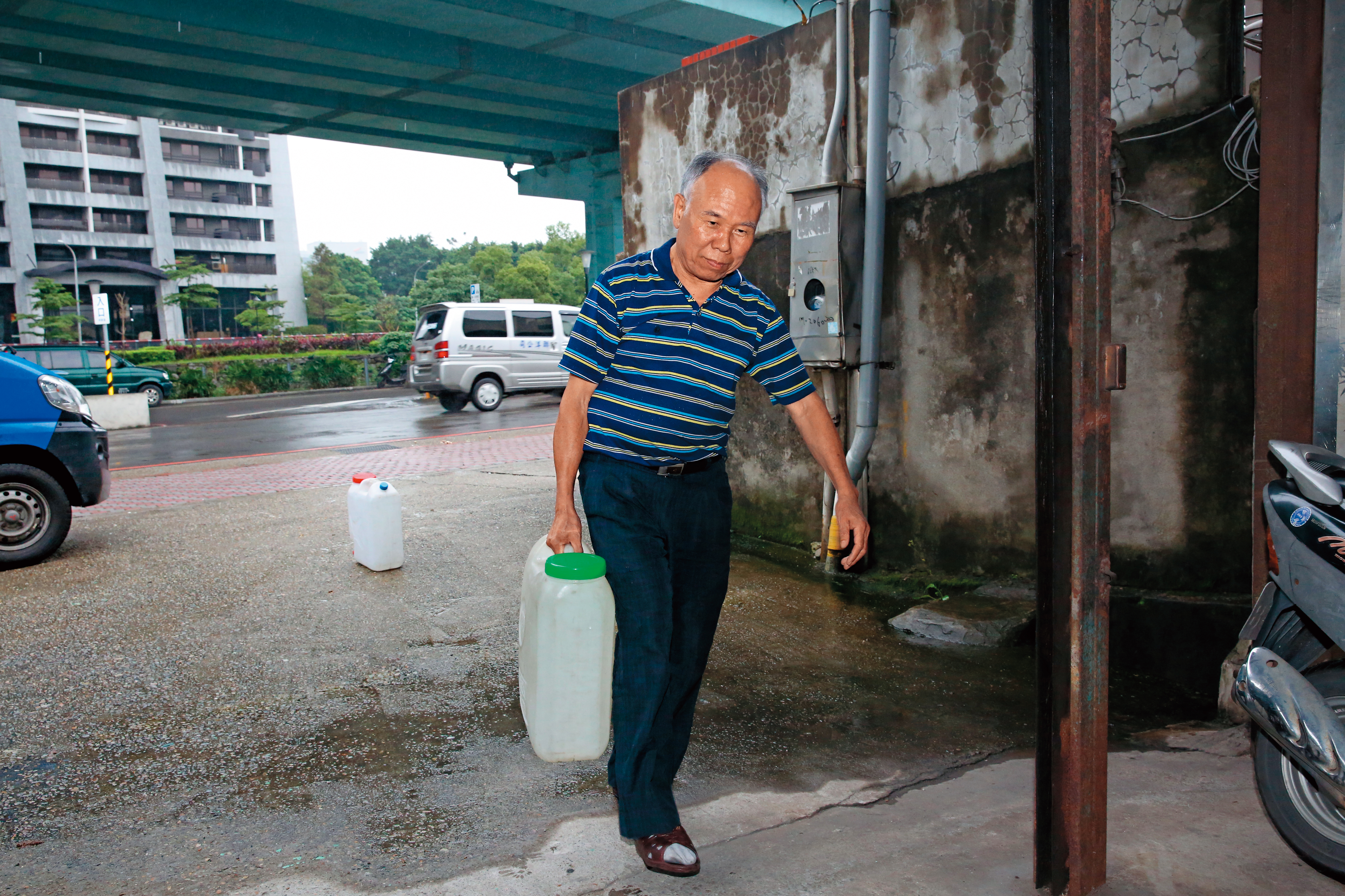 年過70的高老先生長期得買水飲用，提著沉重水桶的踉蹌身影令人心疼。