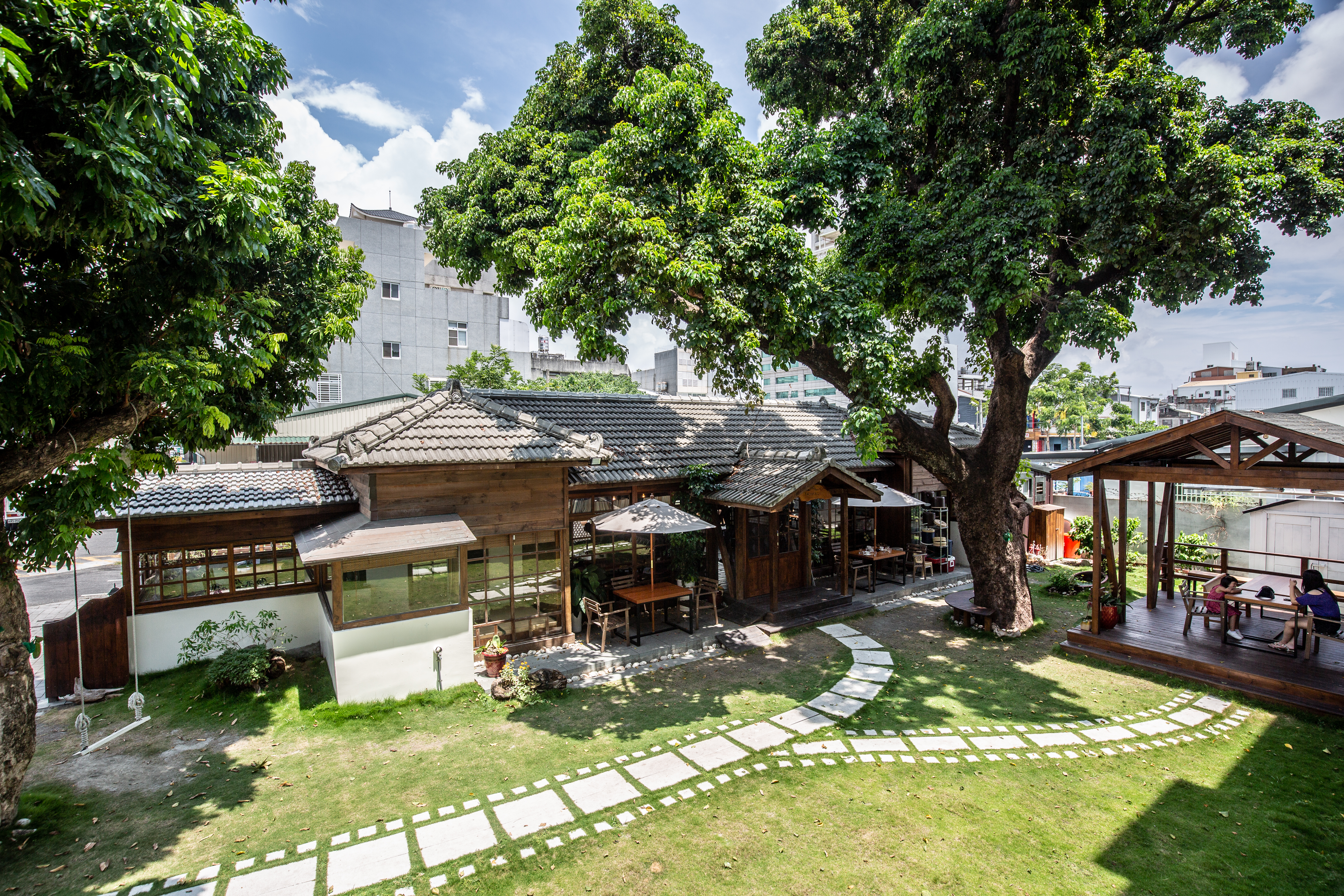 「TAIMALI太麻里文創咖啡館」的日式老宅依偎百年茄苳樹旁,電影膠捲石板道點出主人家身分。