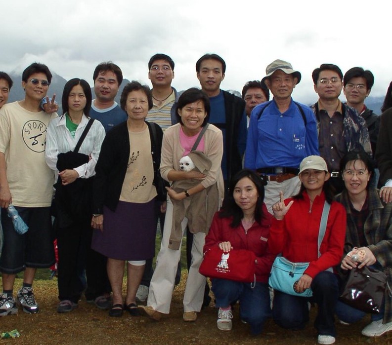 劉郁芬（圖中抱狗者）過去總是一頭短髮、穿著俐落長褲。圖為2005年員工旅遊。（劉郁芬提供）