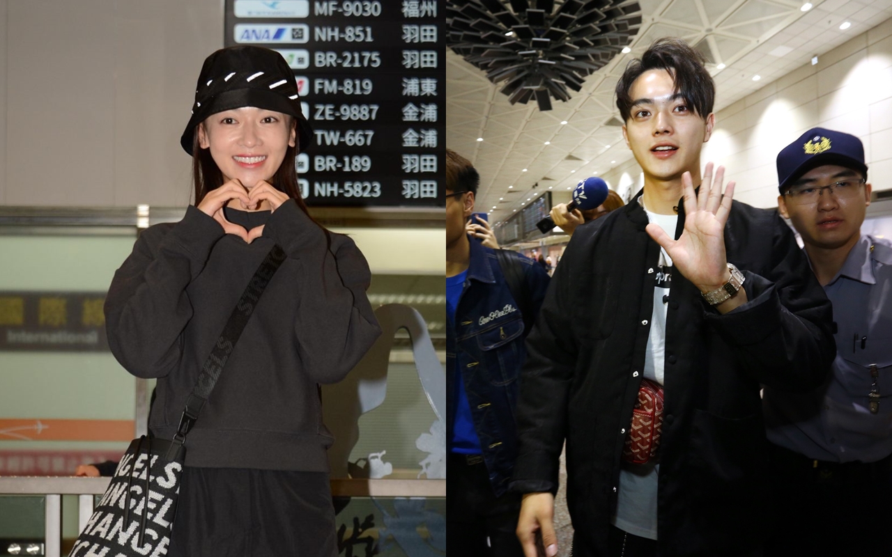 吳謹言（左）展露笑容，比上愛心手勢表示心情。許凱（右）在媒體和粉絲的簇擁下步入機場。（八大提供）
