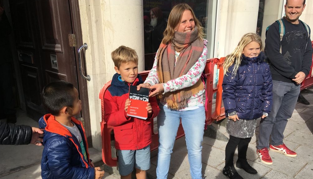 英國南安普敦一間有40年歷史的獨立書店，在社群號召了自願者前來組成人龍，接力把書搬到新店址。（翻攝自十月書店推特）