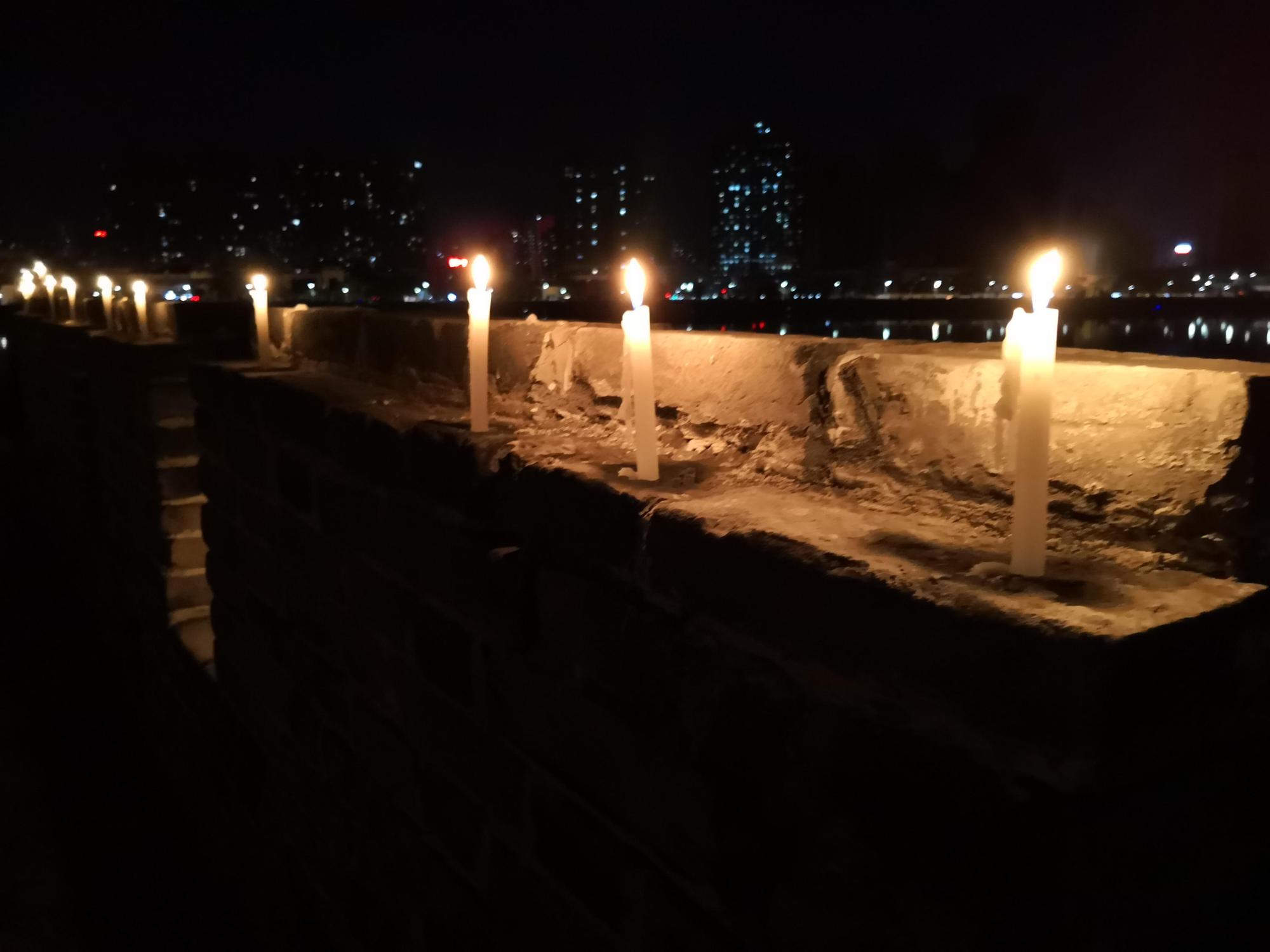 湖北襄陽居民自發點燭,為武俠小說泰斗金庸點亮人生最後一哩路。(東方IC)