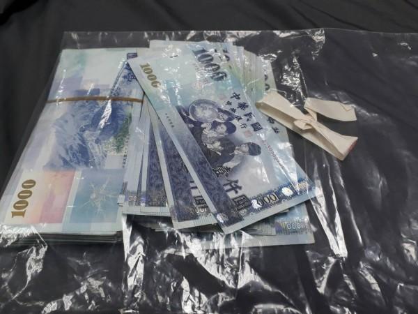 苗栗警調單位在江姓候選人車輛內扣得疑似賄選的現金13萬5000元。（警方提供）