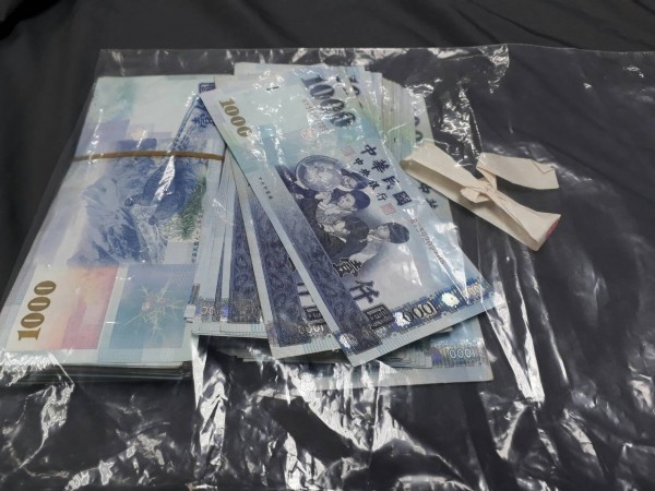 苗栗警調單位在江姓候選人車輛內扣得疑似賄選的現金13萬5000元。（警方提供）