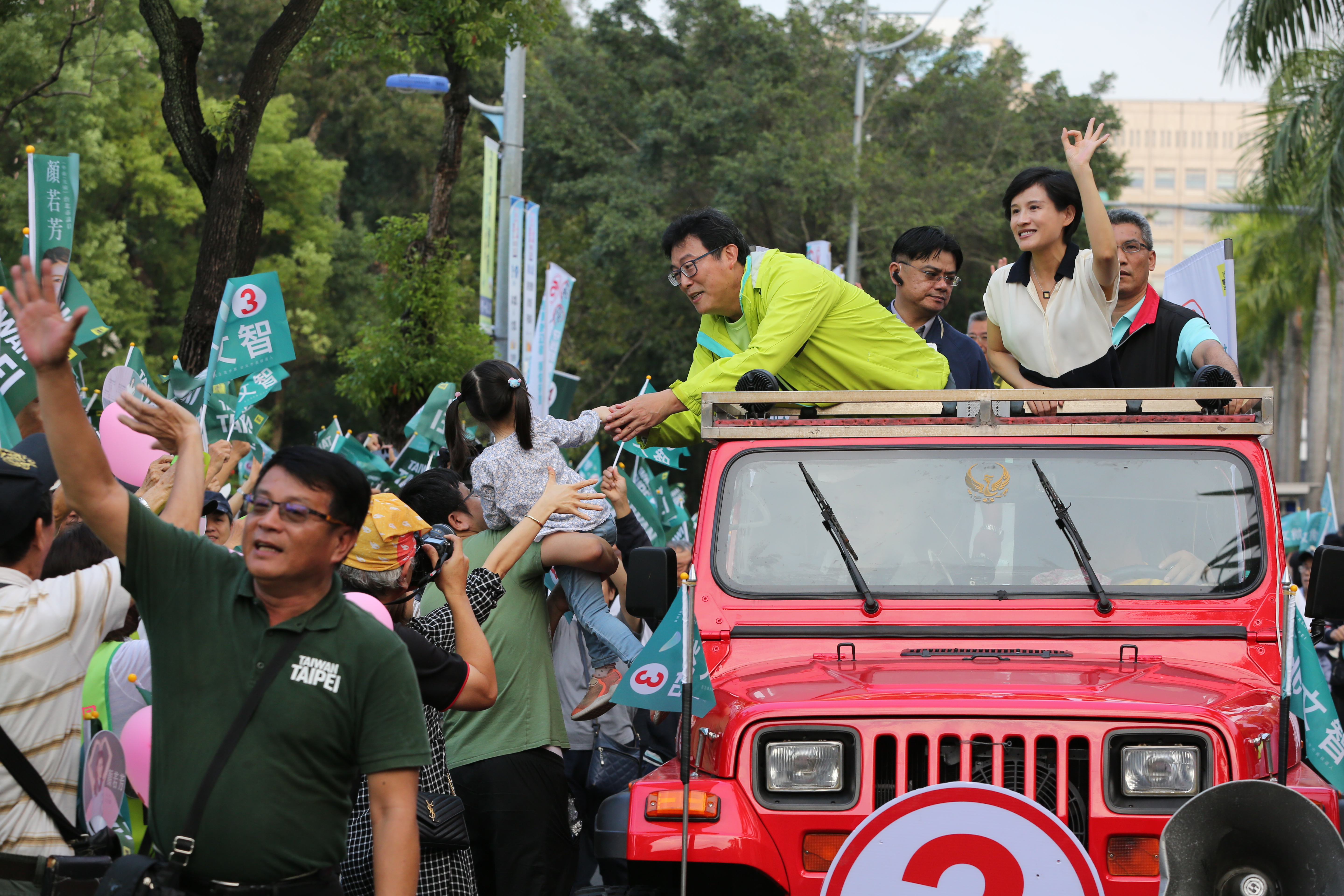 姚文智在文化部長鄭麗君陪同下站在宣傳車上巡迴牽手路線。
