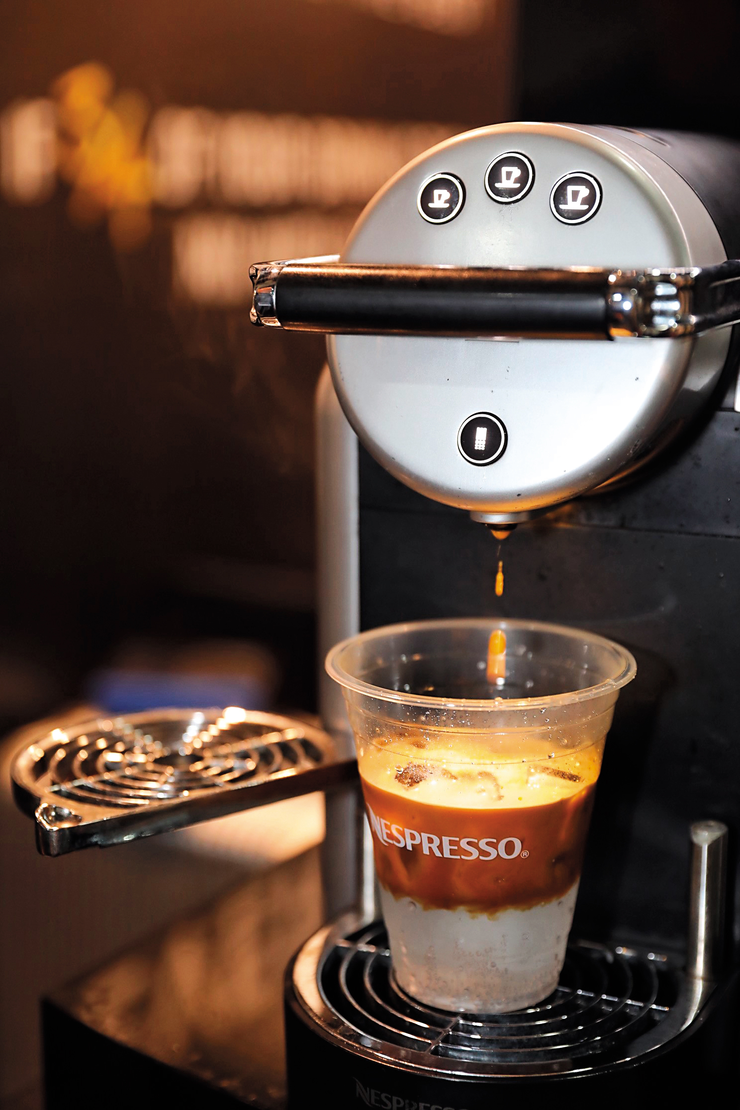 然後把杯子放到Nespresso的機器下，壓一球咖啡。