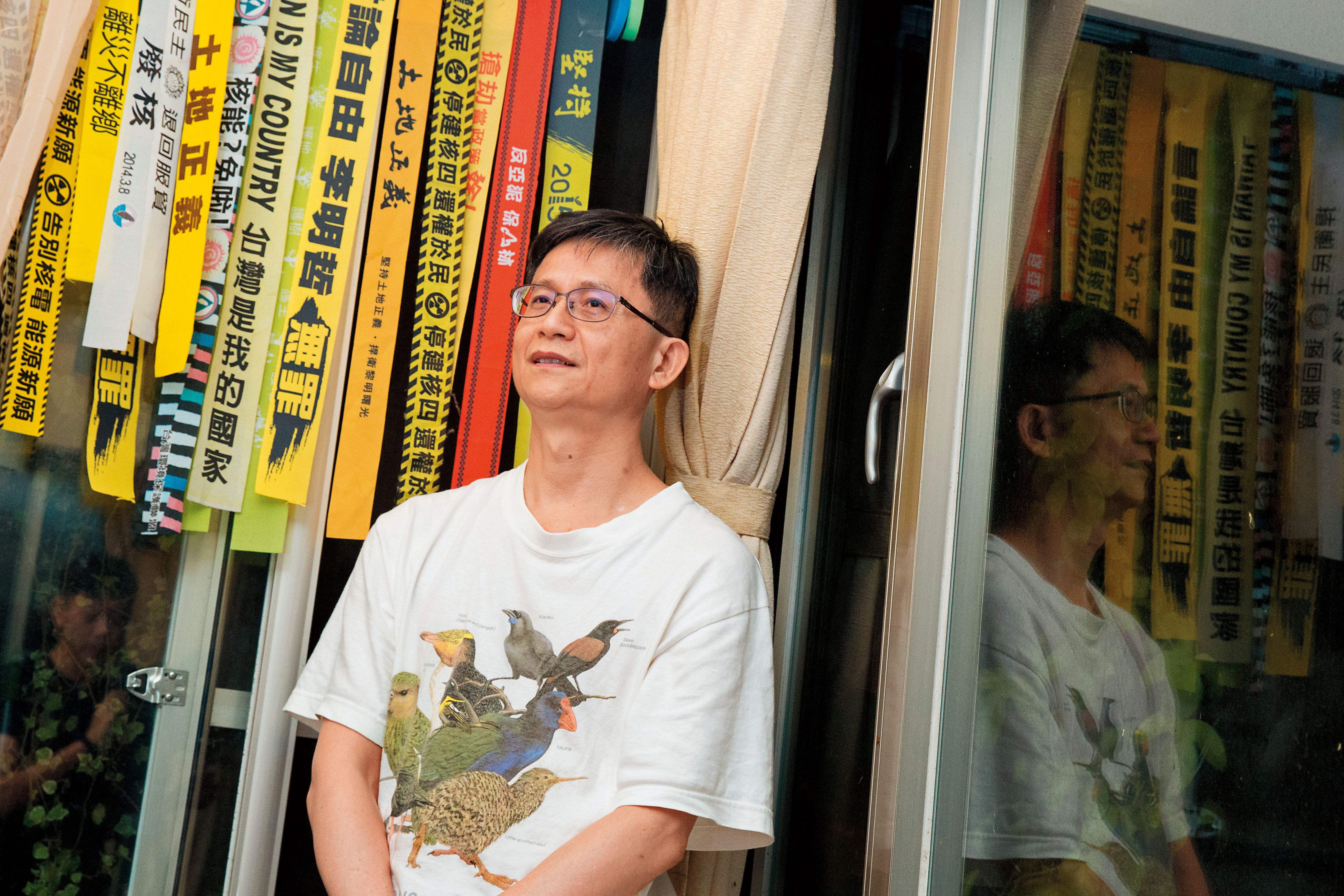 詹順貴家中掛著歷年參與過的抗爭布條，手機殼、水壺也都貼了標語貼紙。