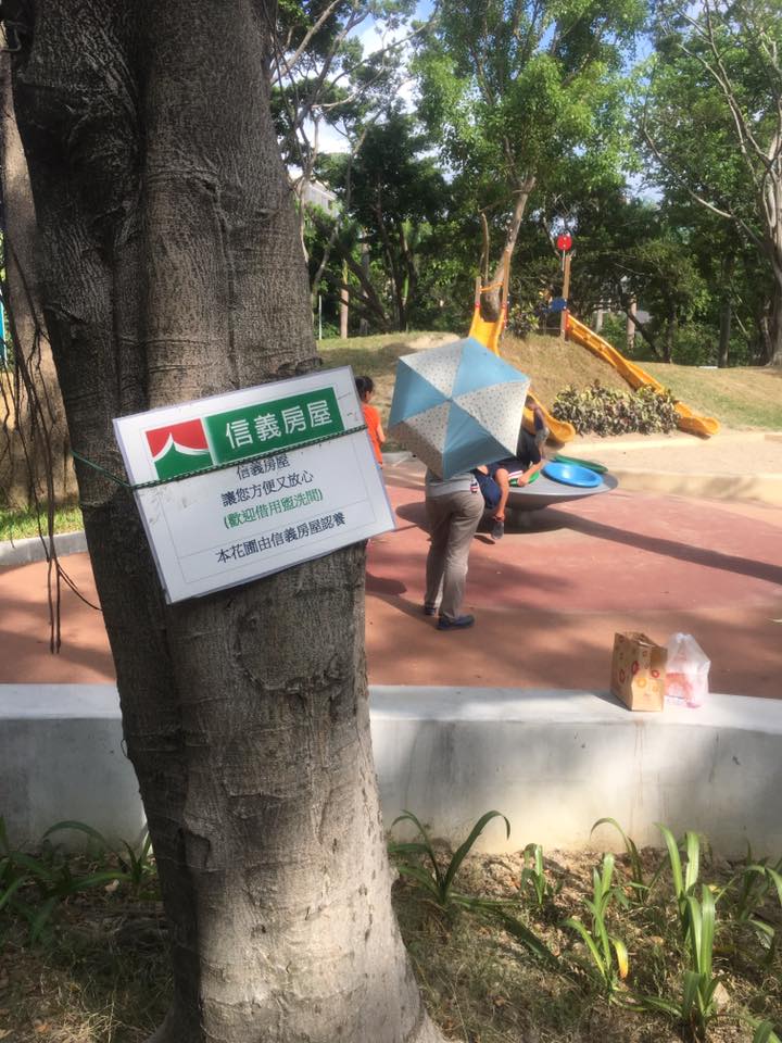 中央公園內花圃置放告示牌，公告信義房屋中央店提供需求民眾借用廁所。