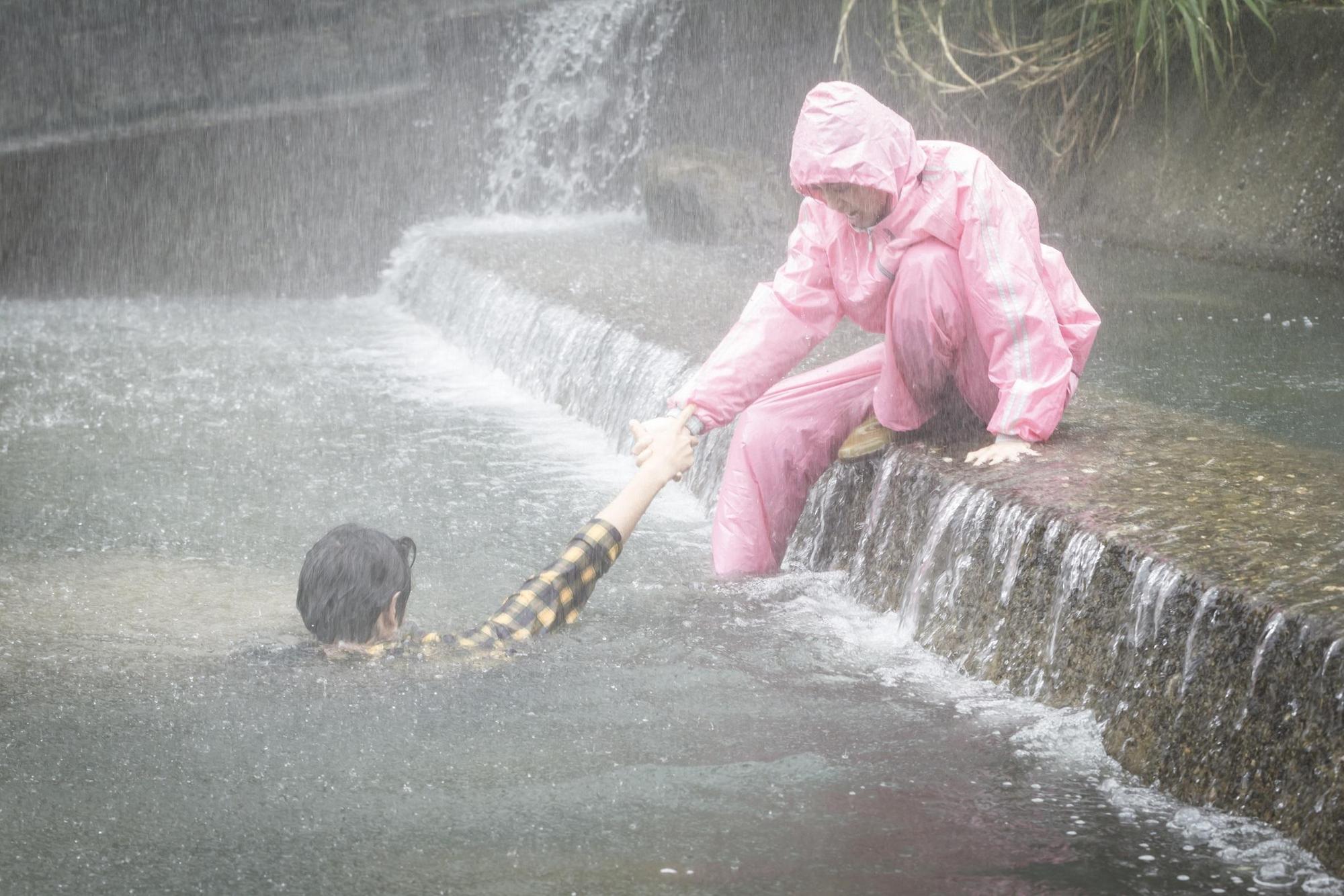陳庭妮穿著粉紅色雨衣救起溺水的劉以豪。(歐銻銻娛樂提供)