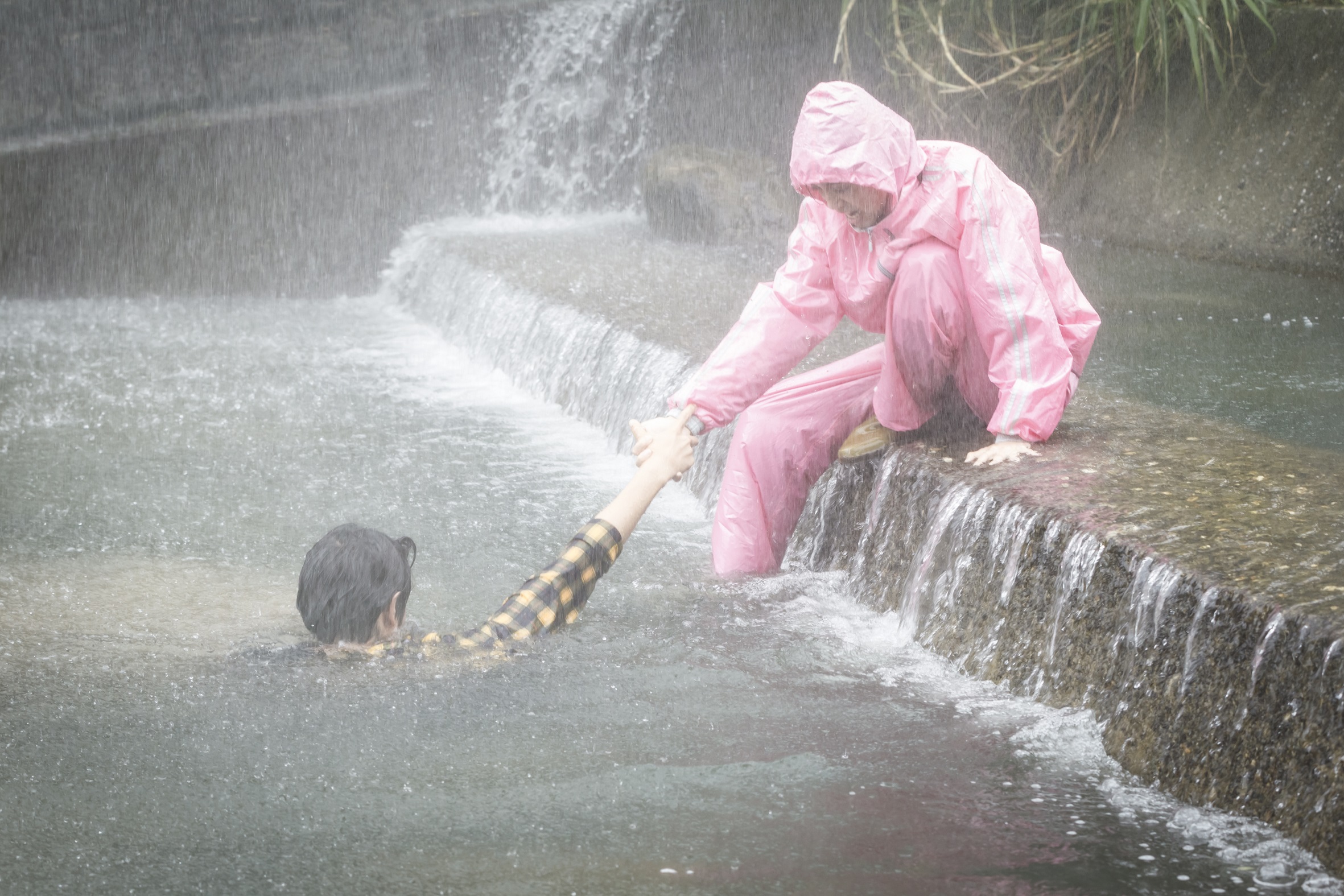 陳庭妮穿著粉紅色雨衣救起溺水的劉以豪。（歐銻銻娛樂提供）
