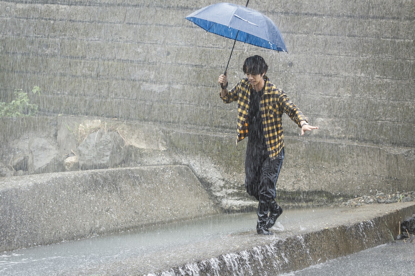 劉以豪在大雨滂沱中演出落水戲。（歐銻銻娛樂提供）