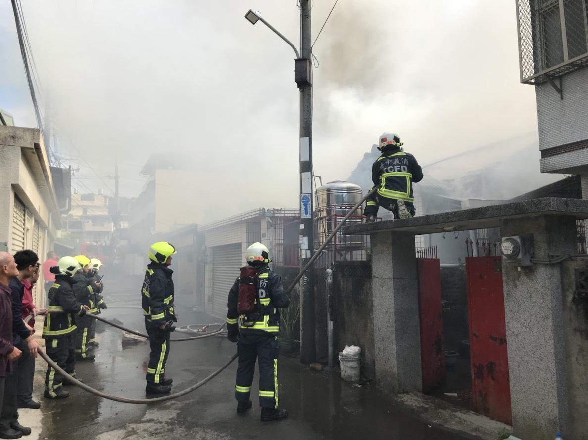 濃煙不斷竄出,消防人員強力噴水降溫,避免延燒四鄰。(消防局提供)