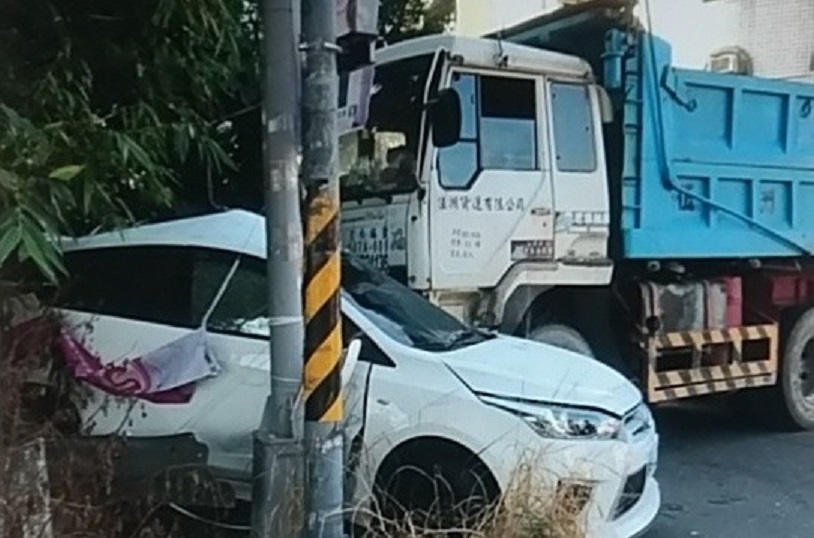 一輛砂石車疑未拉好手煞車，導致車子無預警滑動撞到路旁白色自小客車。（警方提供）