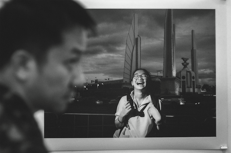 在艾狄雅阿薩拉《十年泰國》的作品中，曼谷民主紀念碑前一個女孩歡笑的照片，為展出埋下了政治氣味。（《十年泰國》臉書粉絲頁）