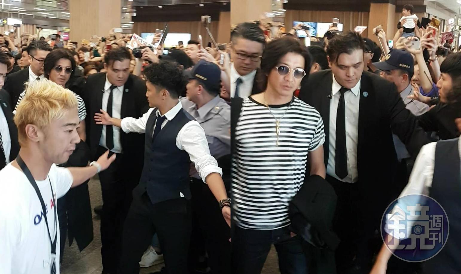 木村拓哉在工作人員保護下,快步離開機場。