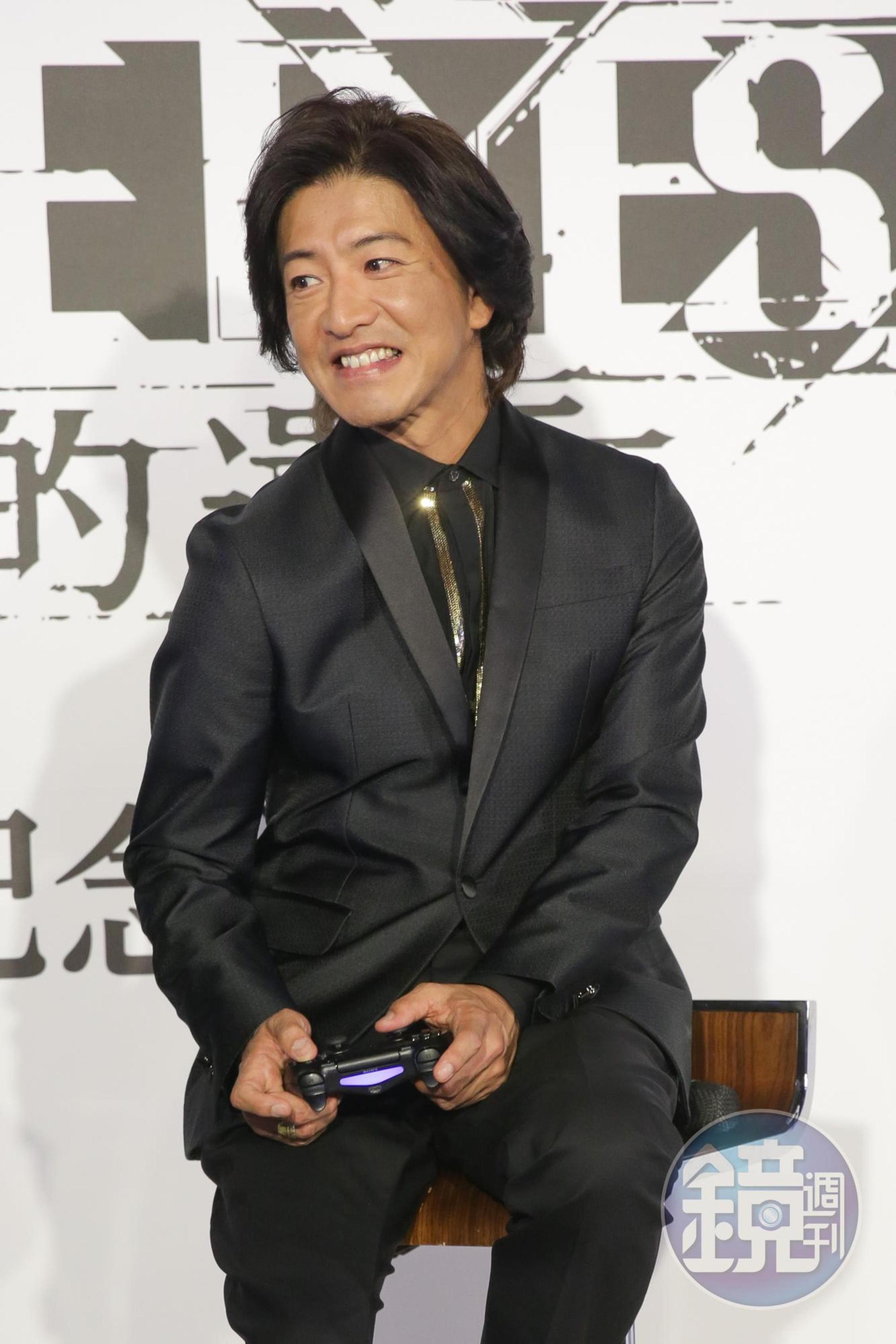 木村拓哉專注在遊戲《審判之眼：死神的遺言》，還扭了一下肩膀，常玩電玩的朋友都很熟這個動作。