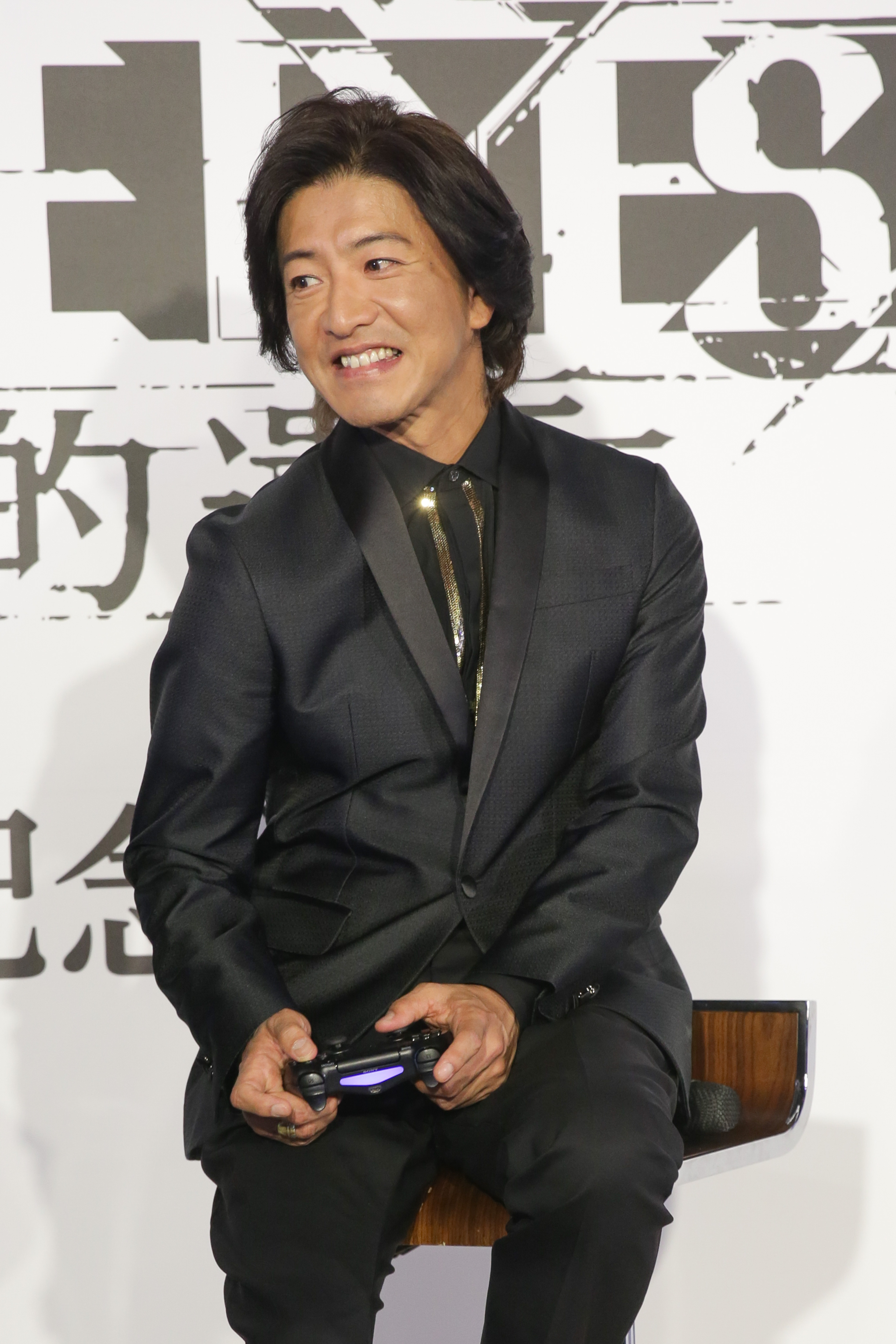 木村拓哉專注在遊戲《審判之眼:死神的遺言》,還扭了一下肩膀,常玩電玩的朋友都很熟這個動作。