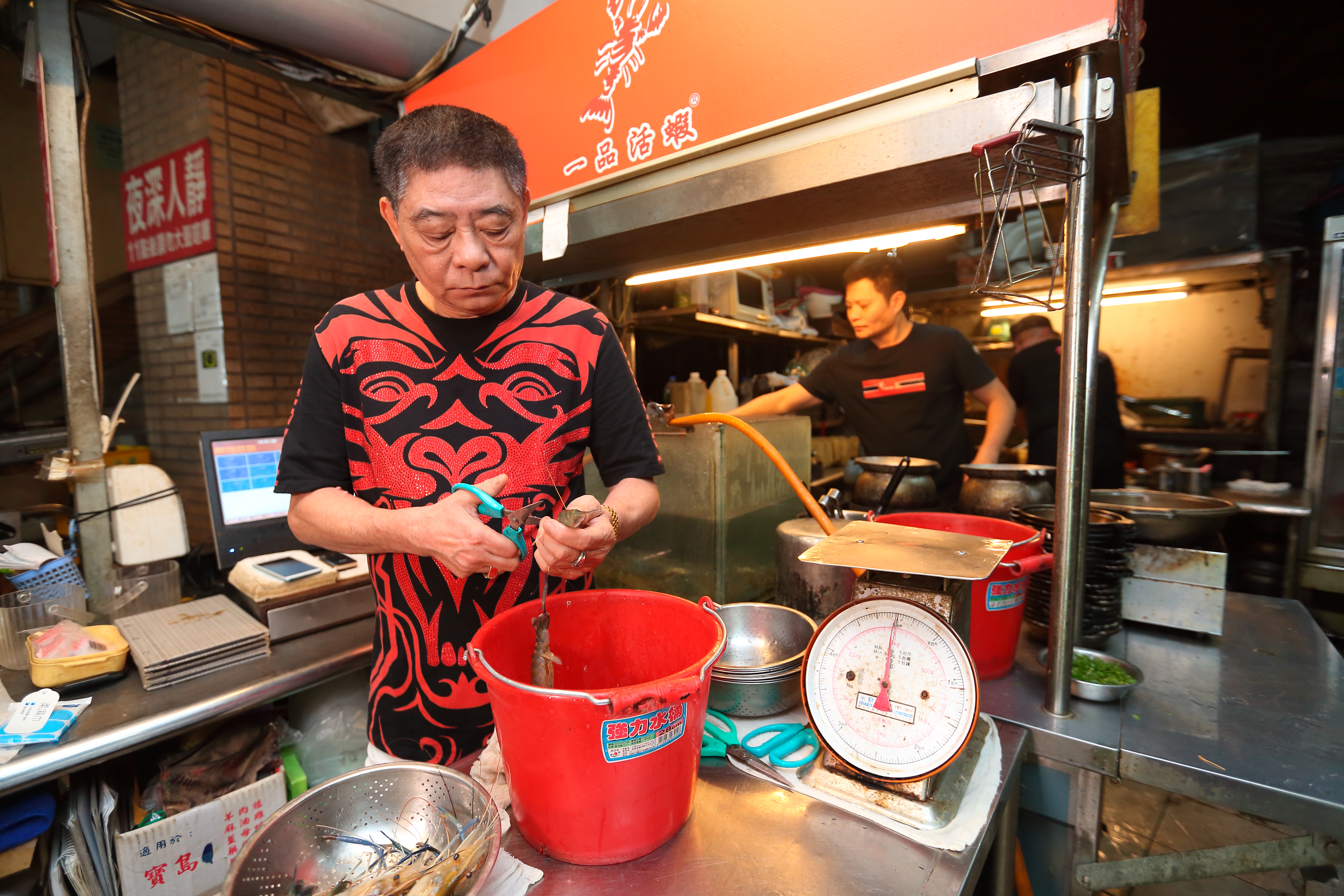 蕭文明剛創業時，父親蕭光熙（前）陪著他每天擺攤、剪蝦、送外賣。