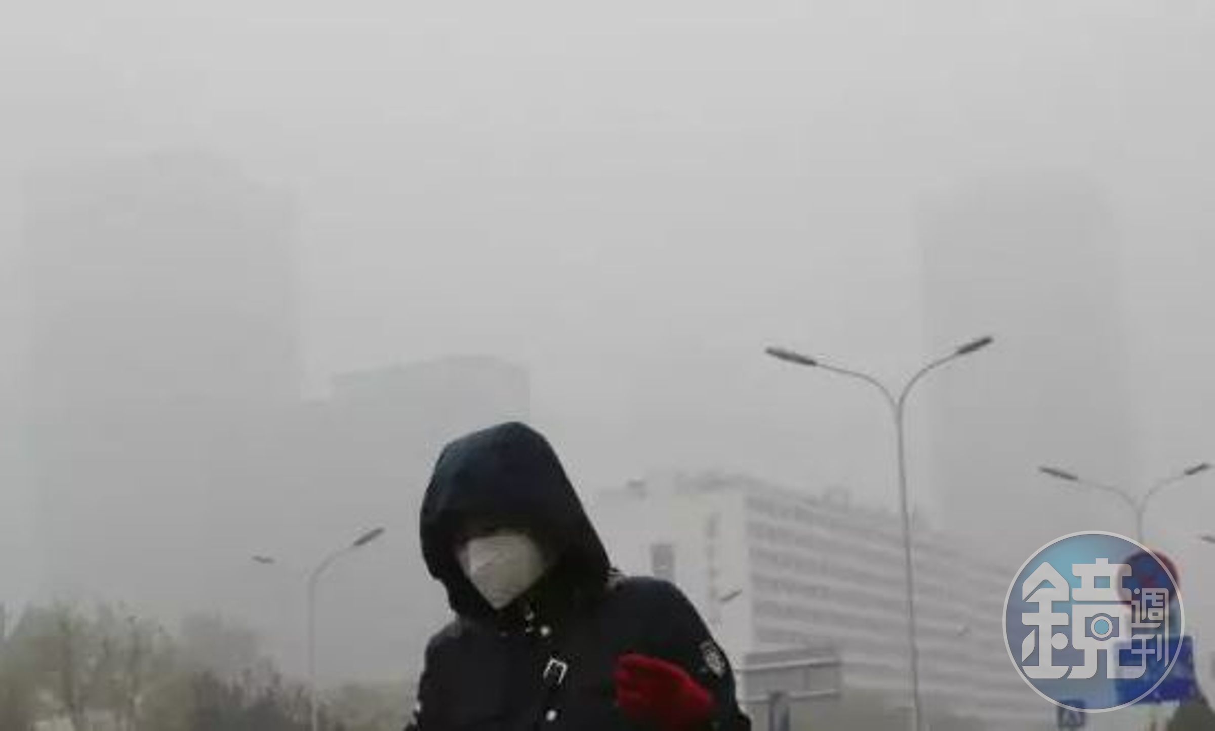 一個戴著口罩的行人走在煙霧繚繞的北京街頭（Andy Wong/AP）