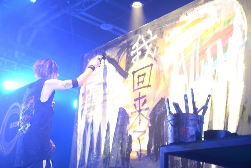 YORKE.在畫版畫上大大的翅膀寫著「我回來了」,相隔2年多再回台北開唱,難掩激動心情。(雅慕斯娛樂提供)