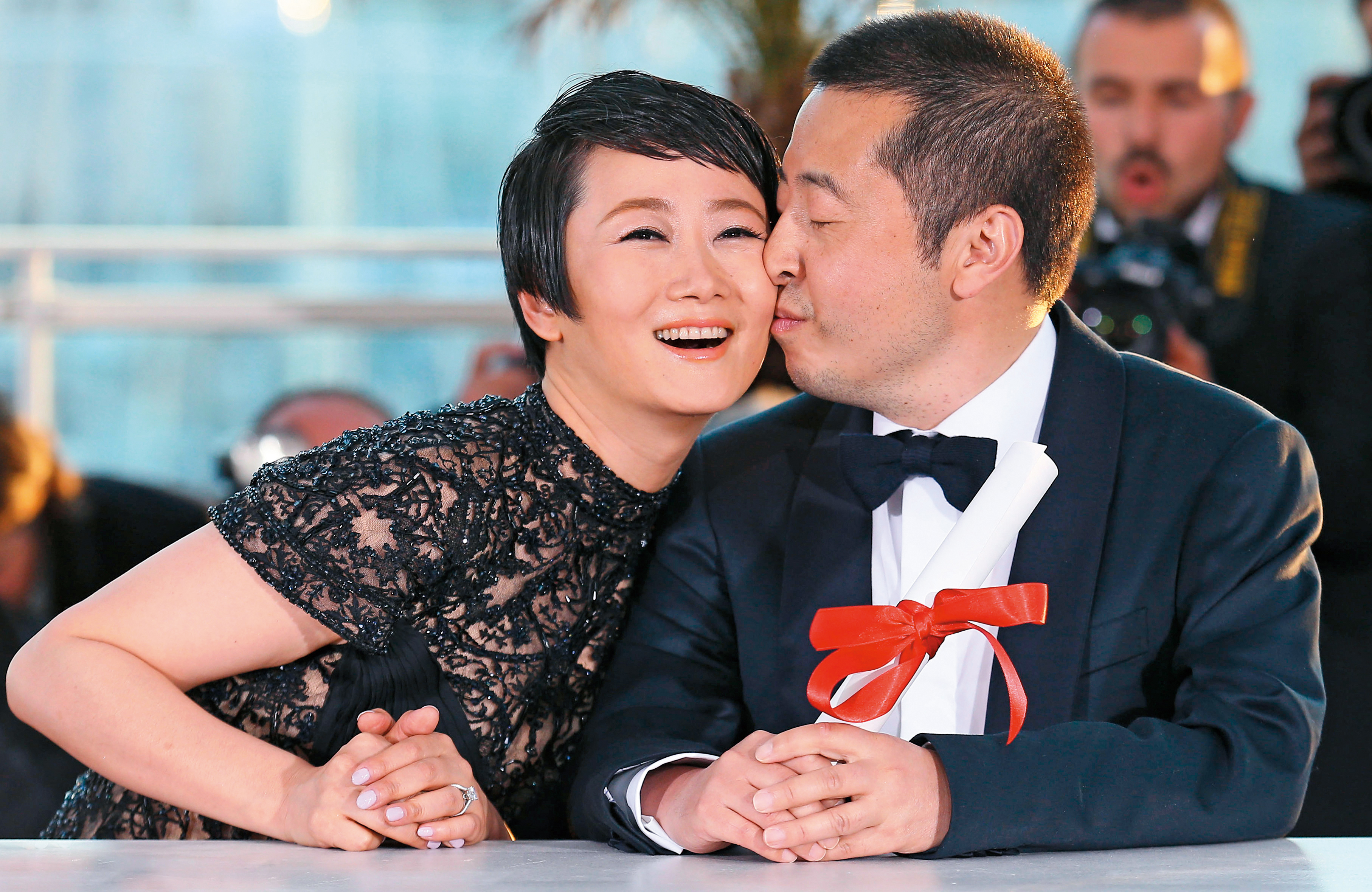 2013年參加坎城影展，趙濤（左）與導演賈樟柯拍照時開心吻在一起。（東方IC） 